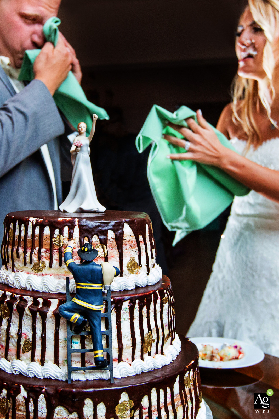Rock Island Lake Club New Jersey wedding venue photo detail of the fireman cake cutting with the bride and groom wiping cake off their faces Rock Island Lake Club New Jersey wedding venue photo detail of the fireman cake cutting with the bride and groom wiping cake off their faces
