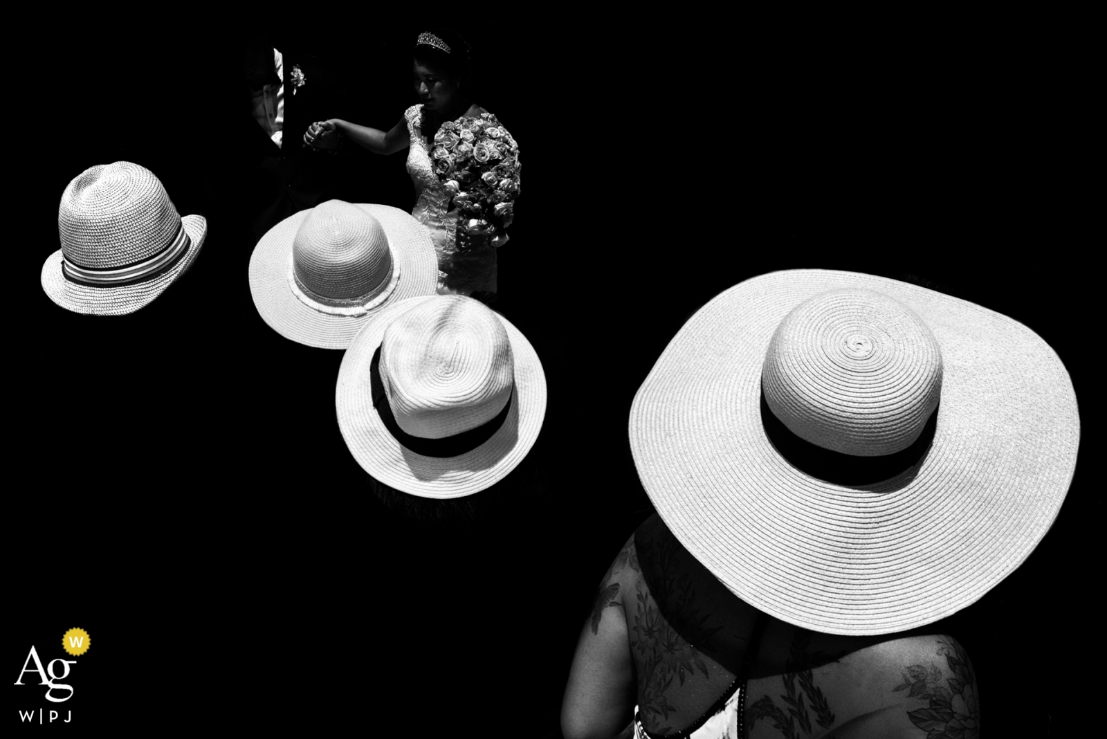 Detalles del día de la boda de los sombreros de los amigos mientras veían a la pareja salir del lugar de la ceremonia al final de la ceremonia,