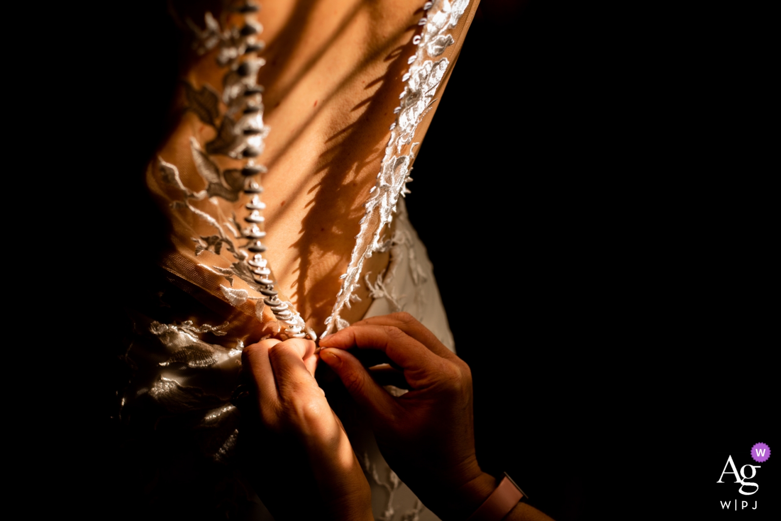 Fotografie der letzten Anpassung auf der Rückseite des Brautkleides im Saal der Hochzeit in Samlesbury