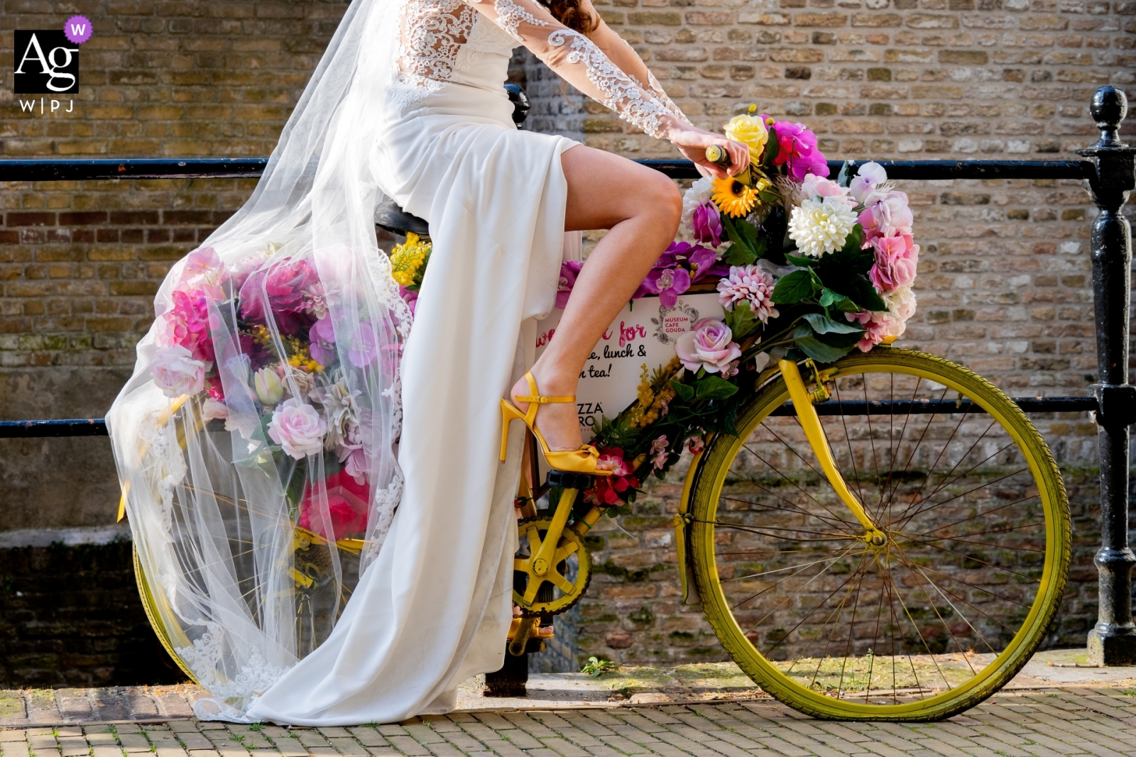 Photographie de mariage aux Pays-Bas, Musée de Gouda | La mariée qui fait du vélo quotidiennement devait prendre une photo sur le vélo jaune, car le jaune était la couleur du thème de leur mariage.