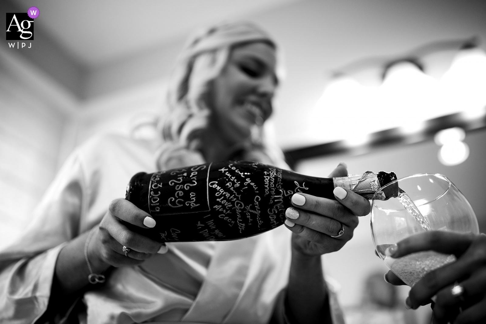 Foto del lugar de la boda en el Broadmoor Hotel, Colorado Springs, Colorado: la dama de honor vierte champán que fue inscrito por los amigos de las novias el día de la boda.