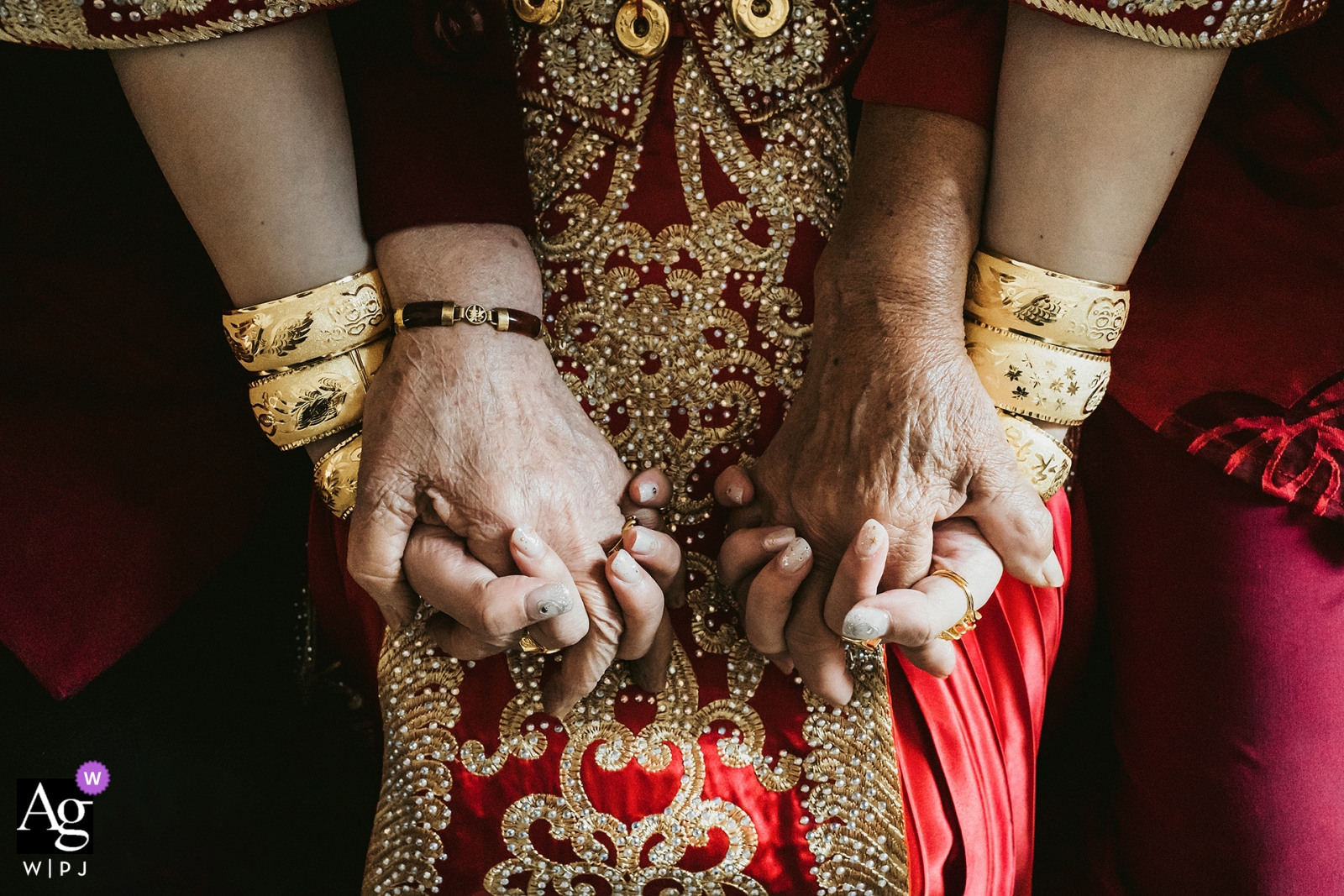 Fujian Bridal Detail Shot: la abuela y la abuela sostienen a la novia con ambas manos