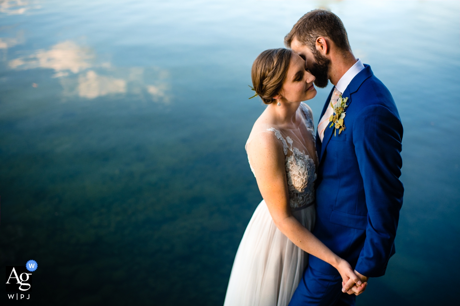 Oakland Maine camp manitou | Bride and groom pose at lake for wedding portraits