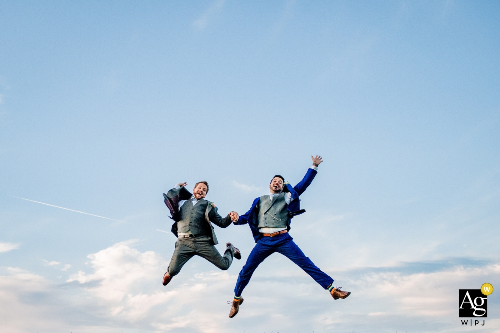 Linganore Winery wedding portraits | Jumping in the air against the blue sky and clouds.