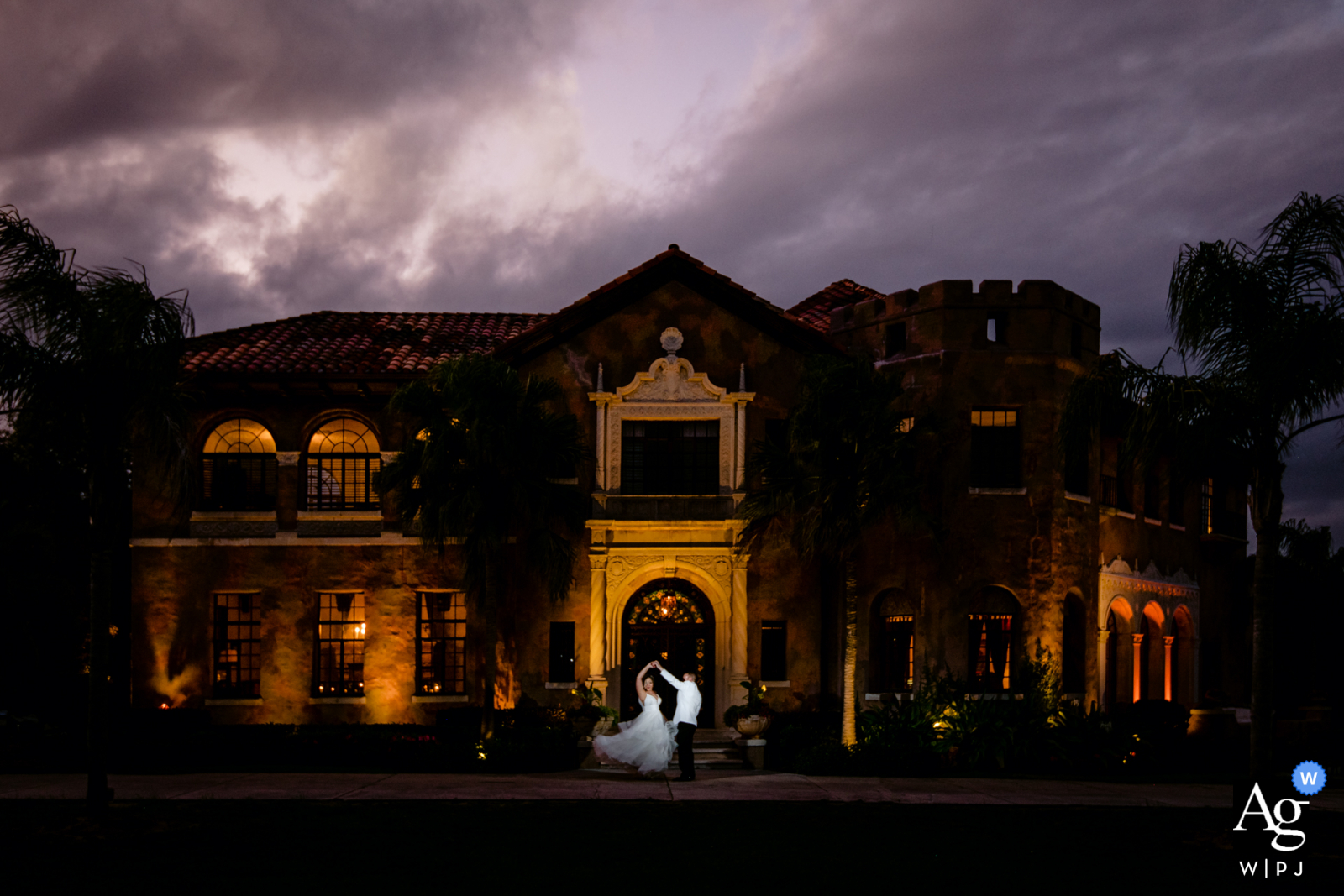 Stormy sunset wedding portrait using the uplighting on the house for ambient light at the Howey Mansion, Orlando, Florida 