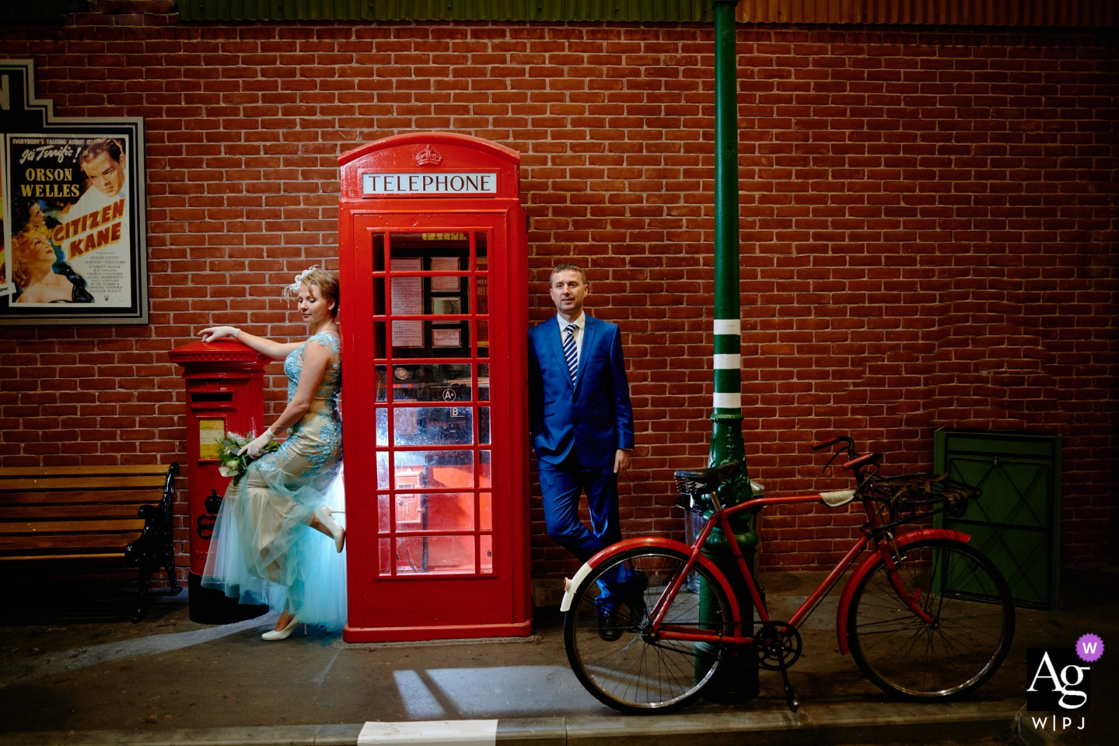 Bride and groom portrait standing next to a vintage UK red phone booth