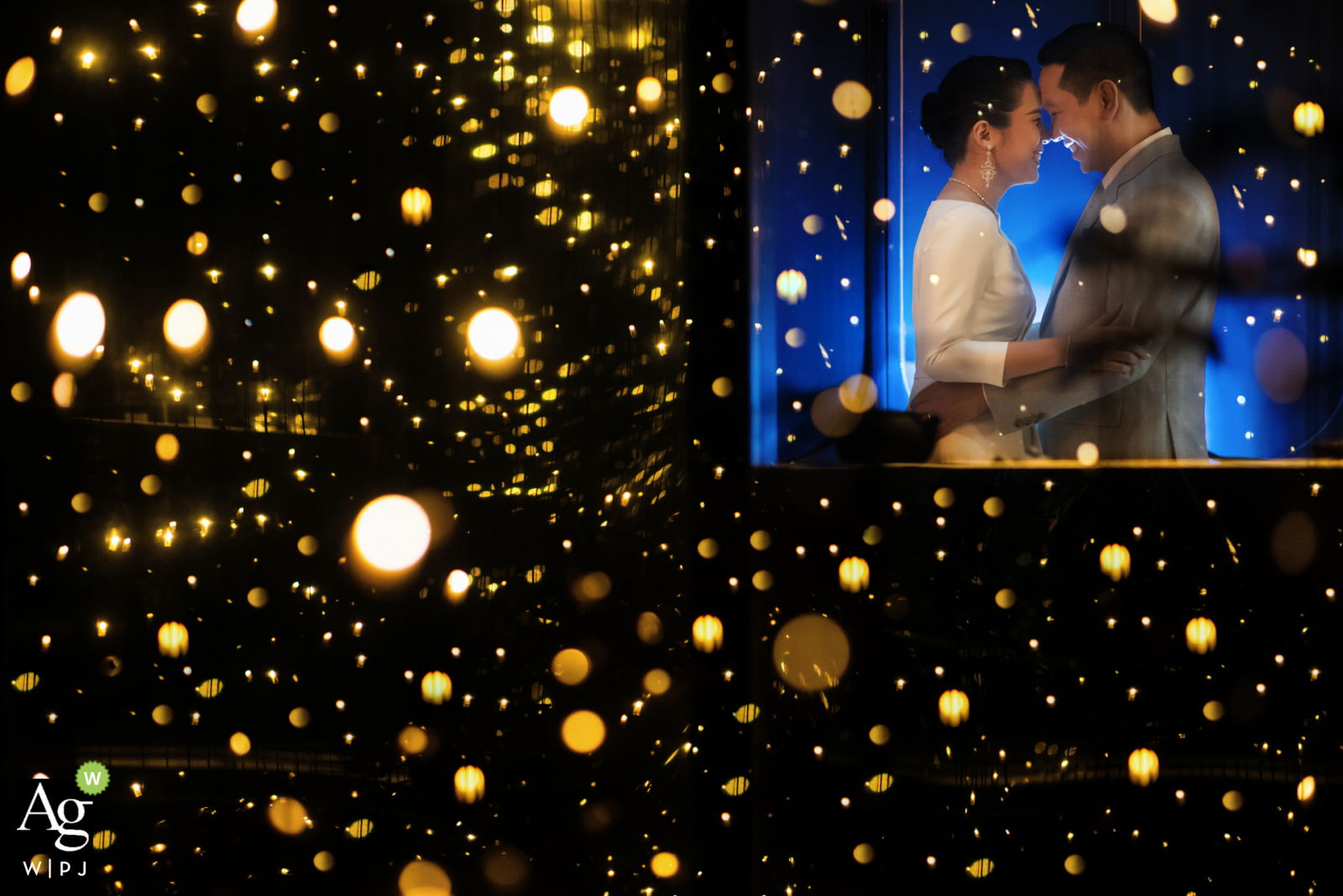 Photo by: <a href="https://www.wpja.com/photos/artistic-wedding-photographers/2595117">Chaiyasith Junjuerdee - Fulham London Rosewood, Bangkok artistic wedding couple portrait with many bokeh lights against a black background