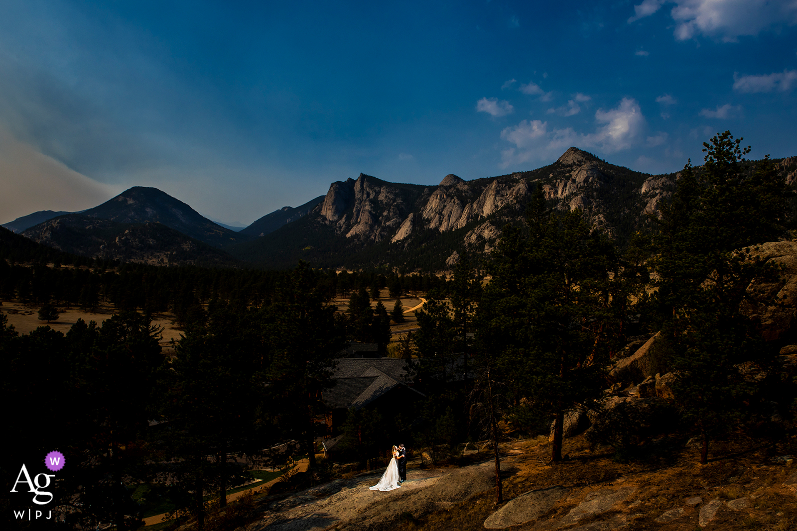 La novia y el novio retrato delante de la vasta cordillera en el Black Canyon Inn en Estes Park, Colorado