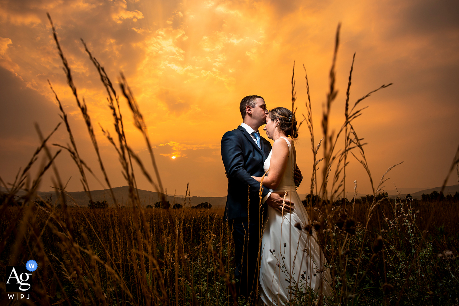 Bride and groom portrait against orange sky at the Shupe Homestead in Hygiene, CO