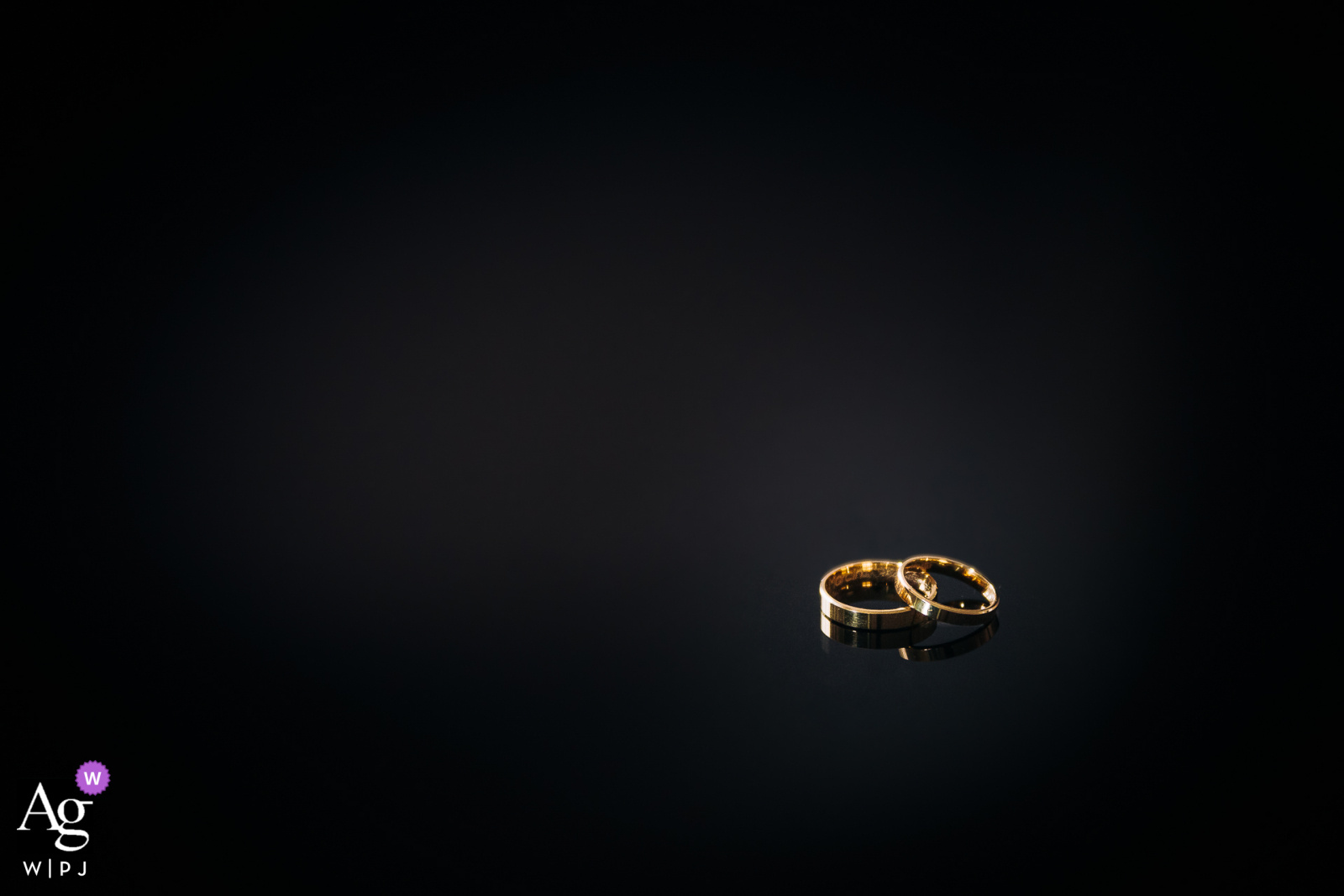 A close-up of the wedding rings of the bride and groom lying on a dark table at the "On the hill" Mansion in Lodz, Poland