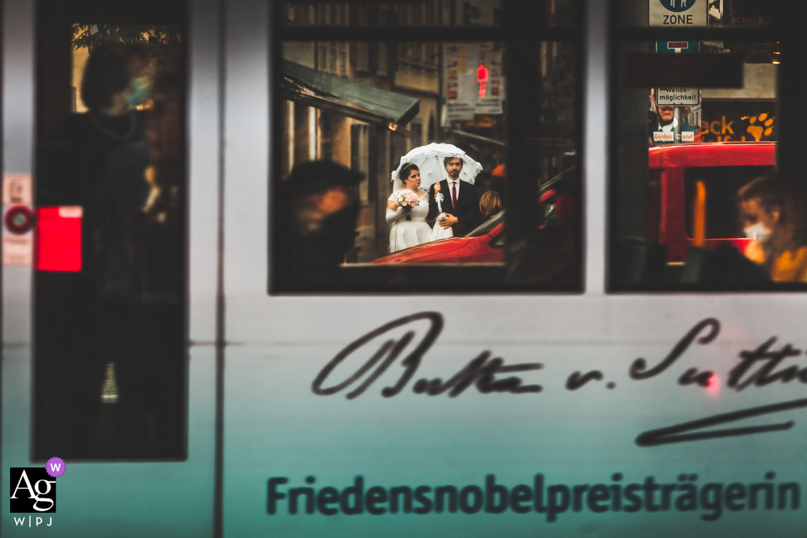 Bonn. Germany Couple at a pedestrian crossing during an urban wedding day portrait session in the rain with an umbrella