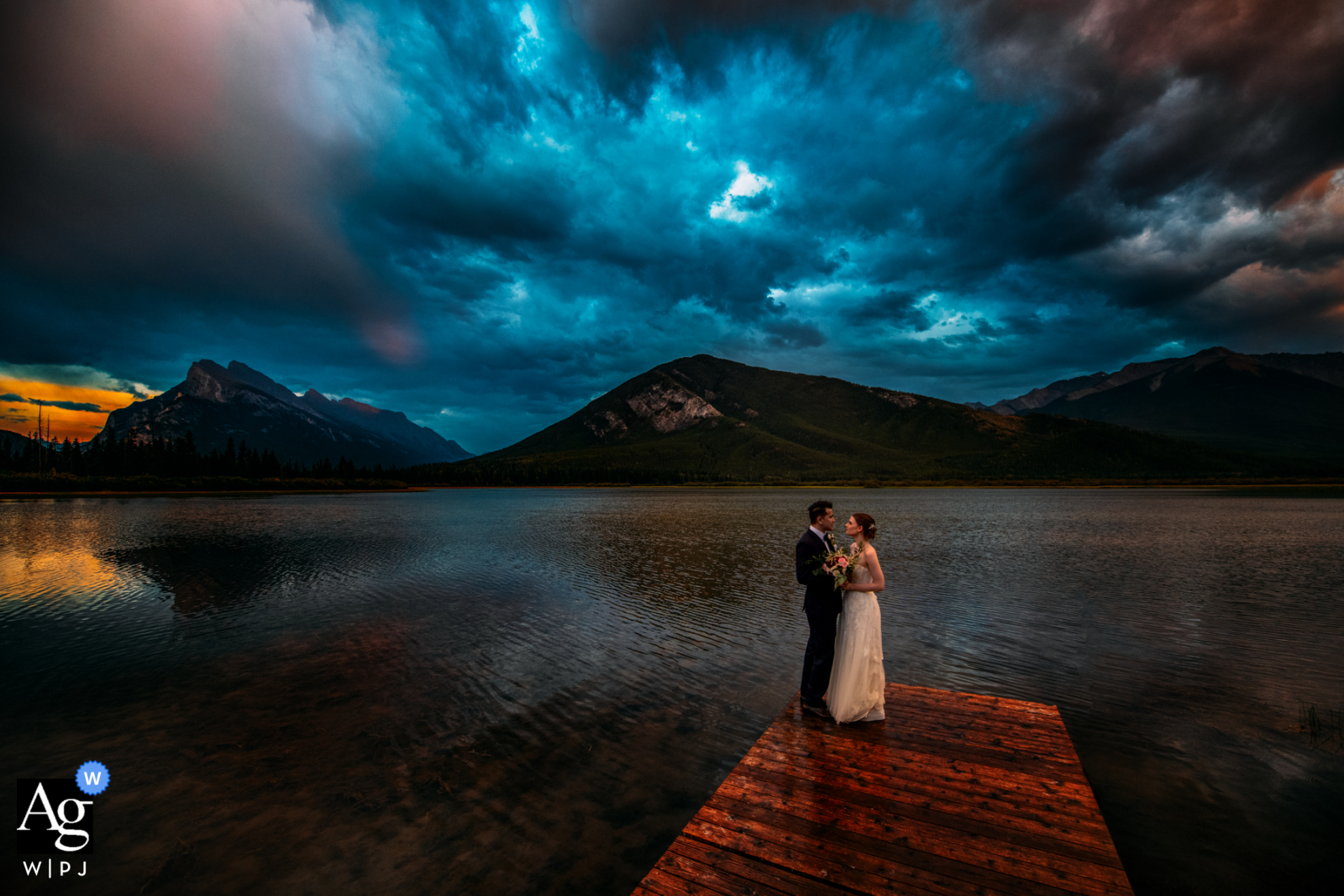 Hochzeitstag in Vermilion Lakes, AB, Kanada Sonnenuntergangsporträt der Braut und des Bräutigams auf einem Holzsteg