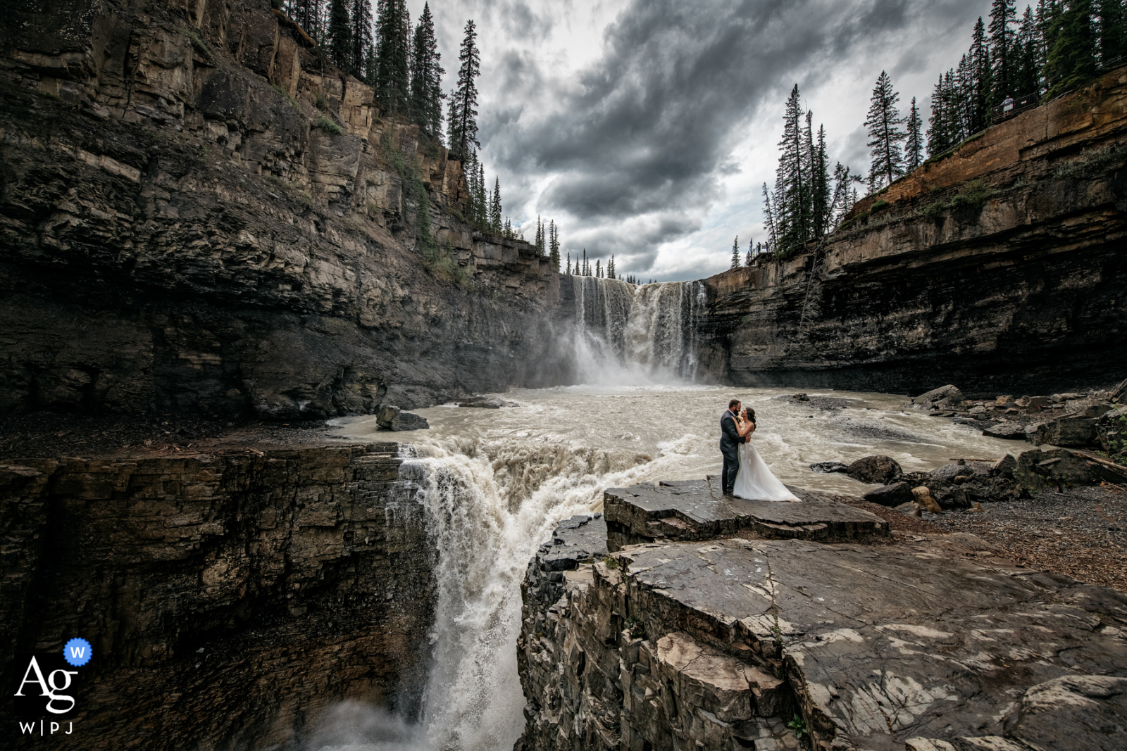 Fotografía artística de bodas en Crescent Falls, AB, Canadá con un abrazo en las cascadas