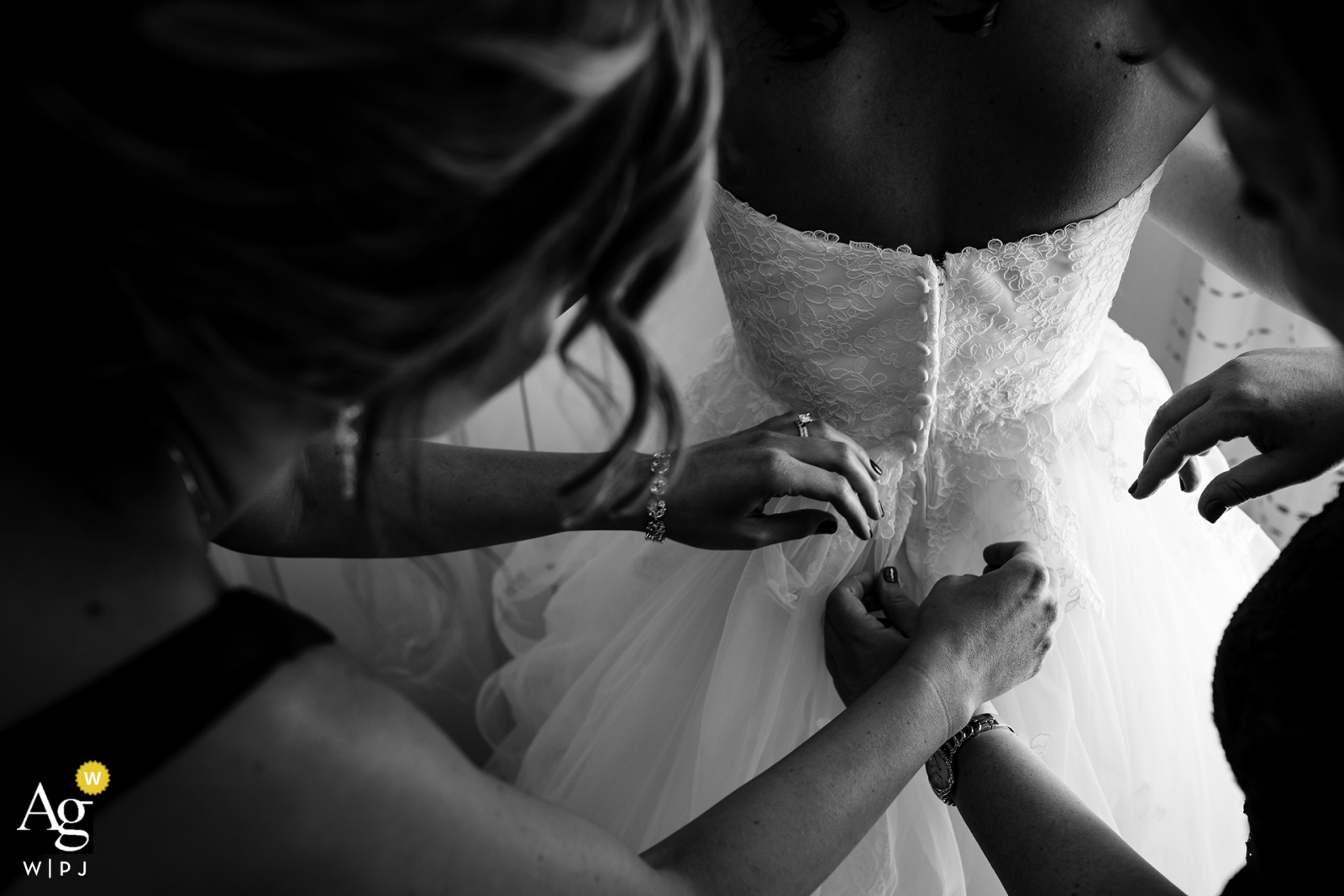 Philadelphia bride gets some help from her mom and sister putting on her wedding gown 