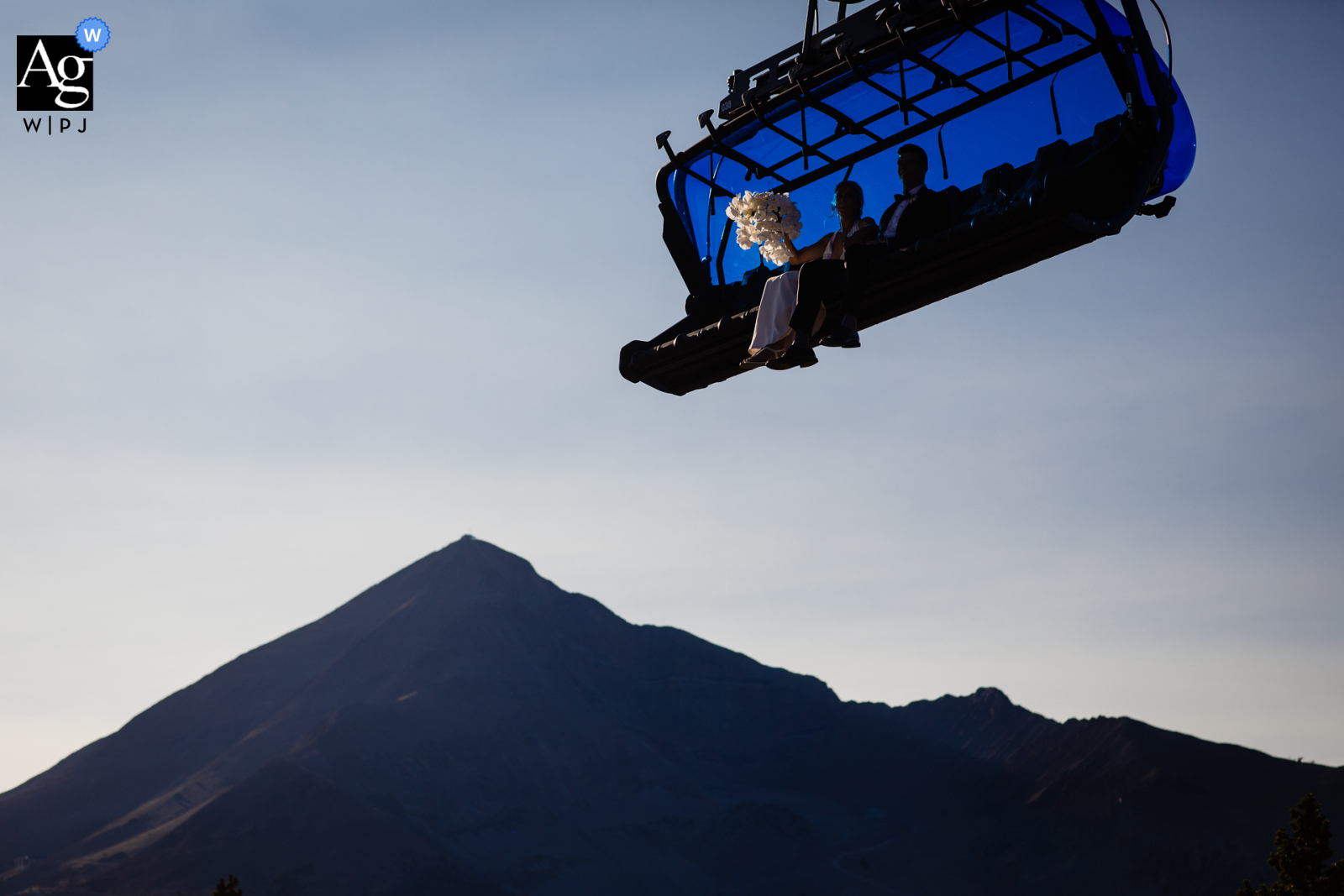 Foto artística de casamento no grande céu de Montana mostrando um buquê no teleférico da estação de esqui