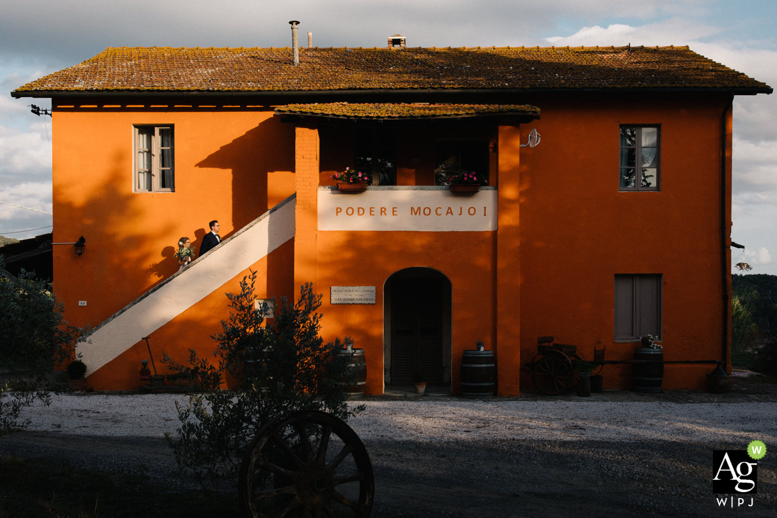 Tenuta Mocajo, Toscana boda los novios subiendo las escaleras de una casa de campo mientras posan para un retrato