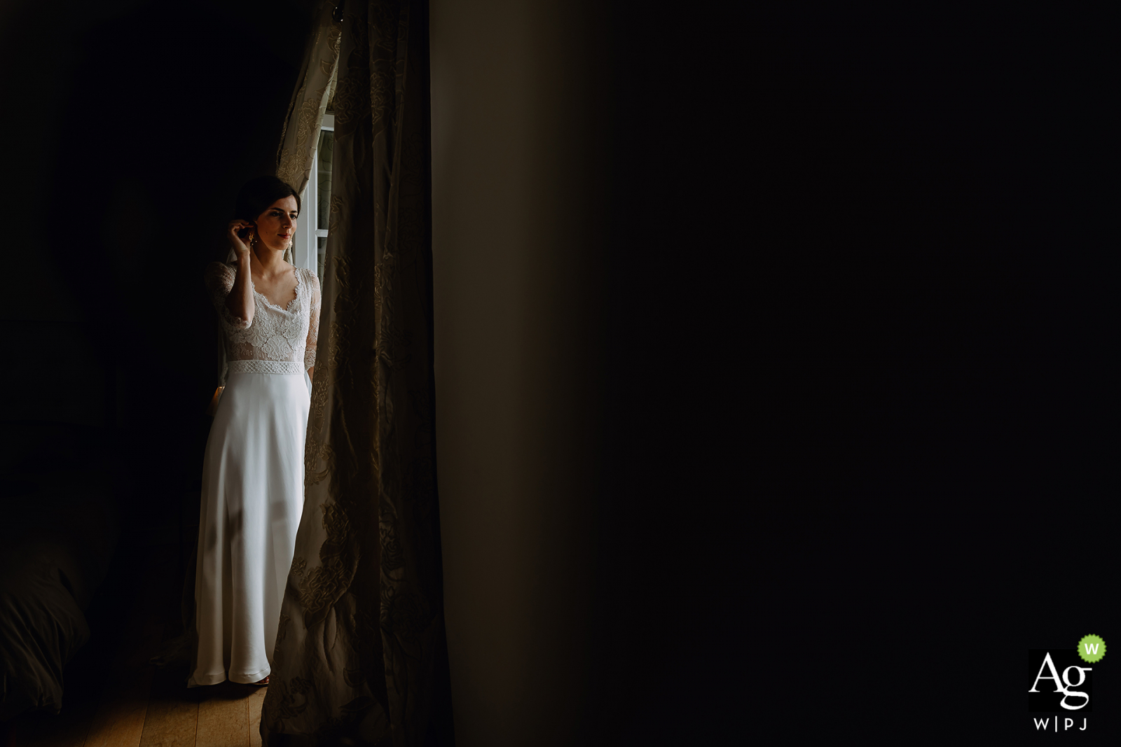 Auvergne-Rhône-Alpes wedding bride posing for a portrait next to a window opening with natural lighting Auvergne-Rhône-Alpes wedding bride posing for a portrait next to a window opening with natural lighting