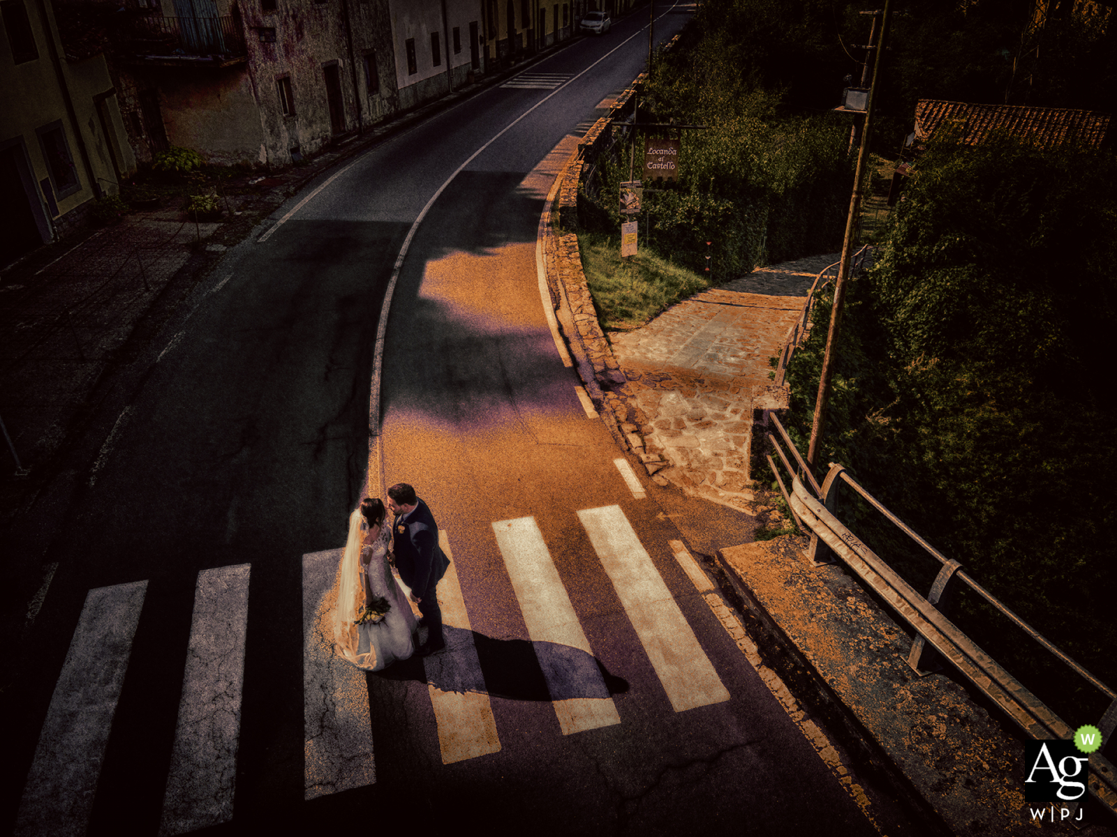 Verrucola Massa bride and groom posing during a portrait session on the street crosswalk under the afternoon sun and road shadows