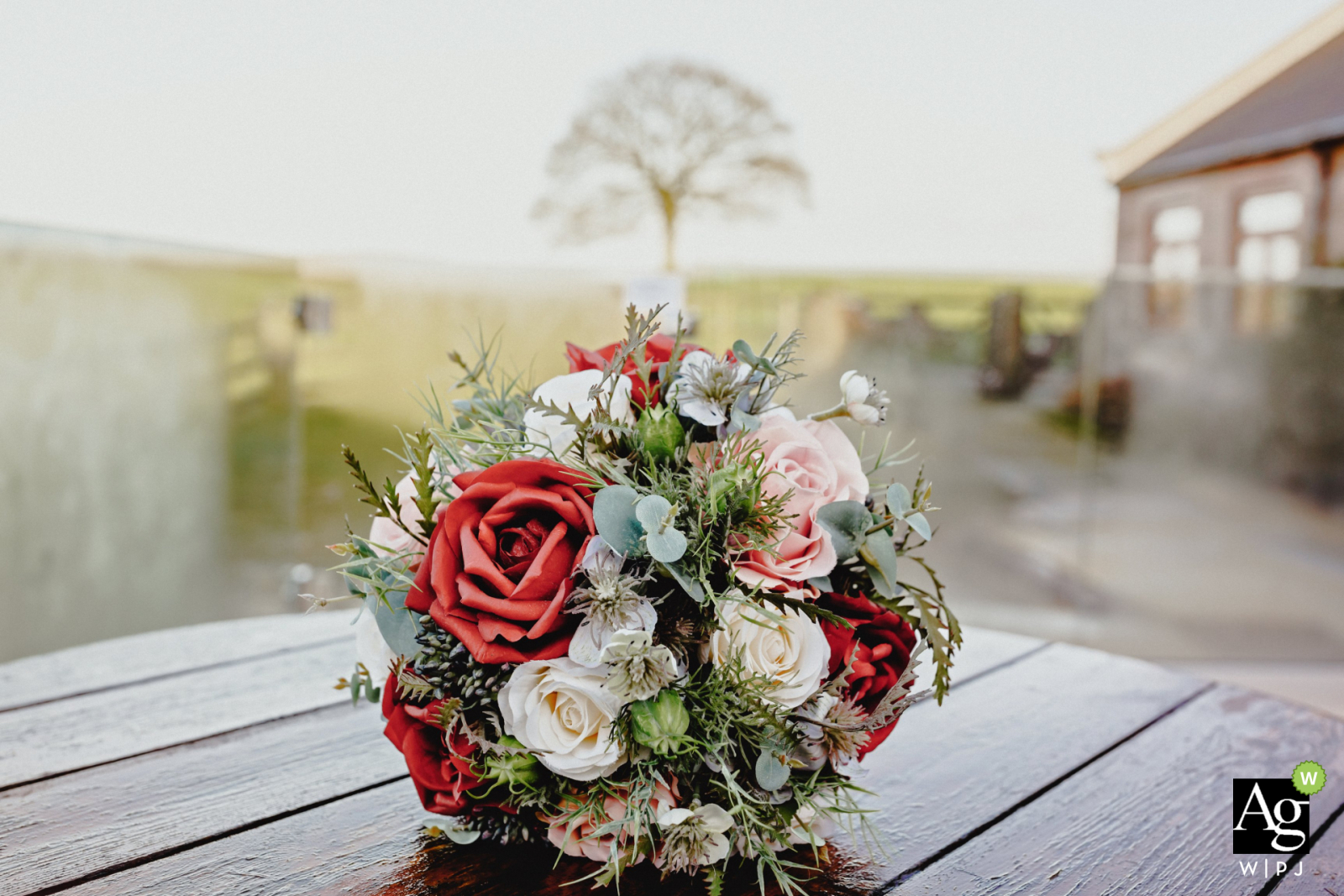 Heaton House Farm, Manchester, Inglaterra fotografía de detalle de boda mostrando el ramo de novias con árbol en segundo plano.