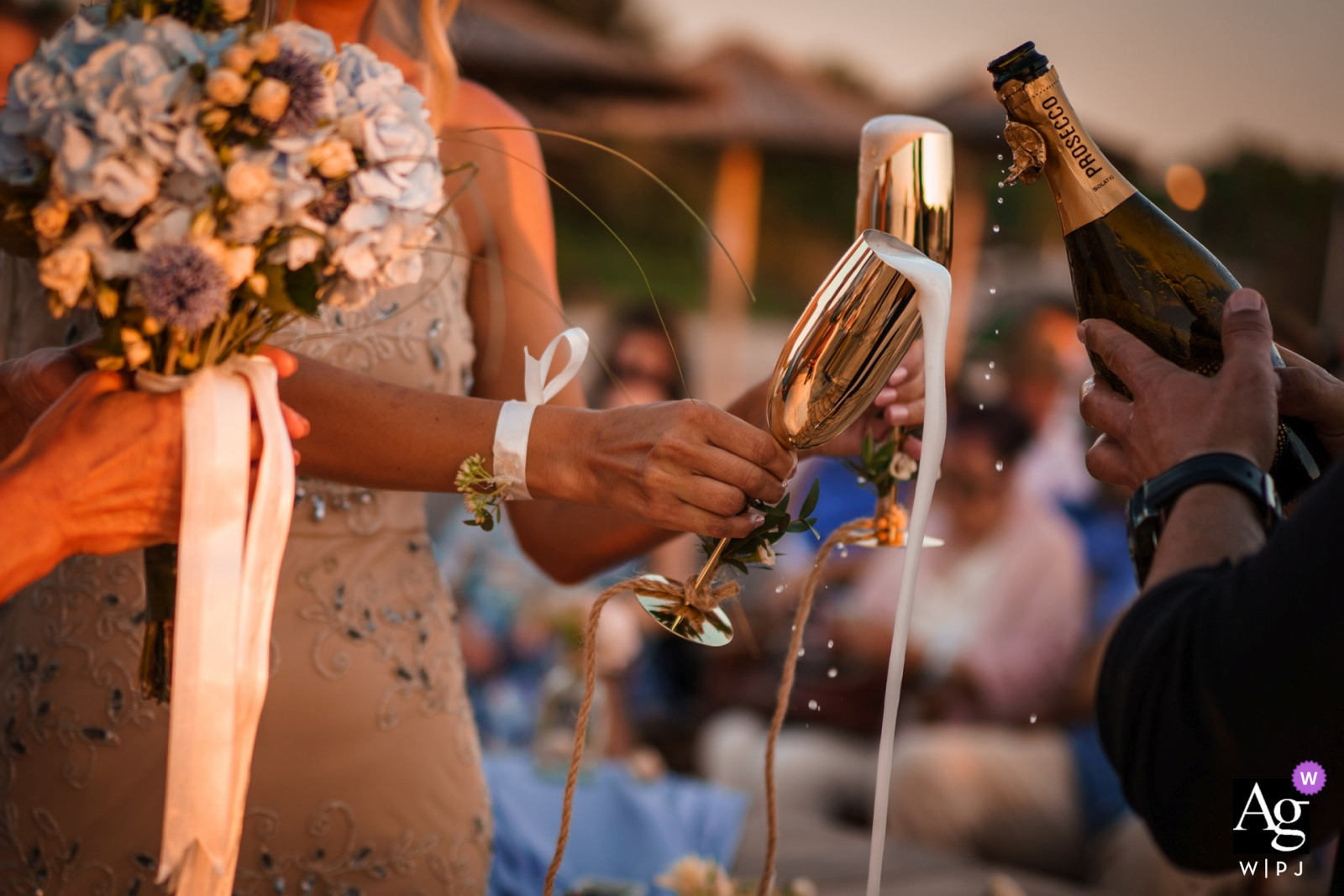 Imagem detalhada do casamento no Mar Negro do padrinho servindo champanhe durante a cerimônia na praia e bar de Papur