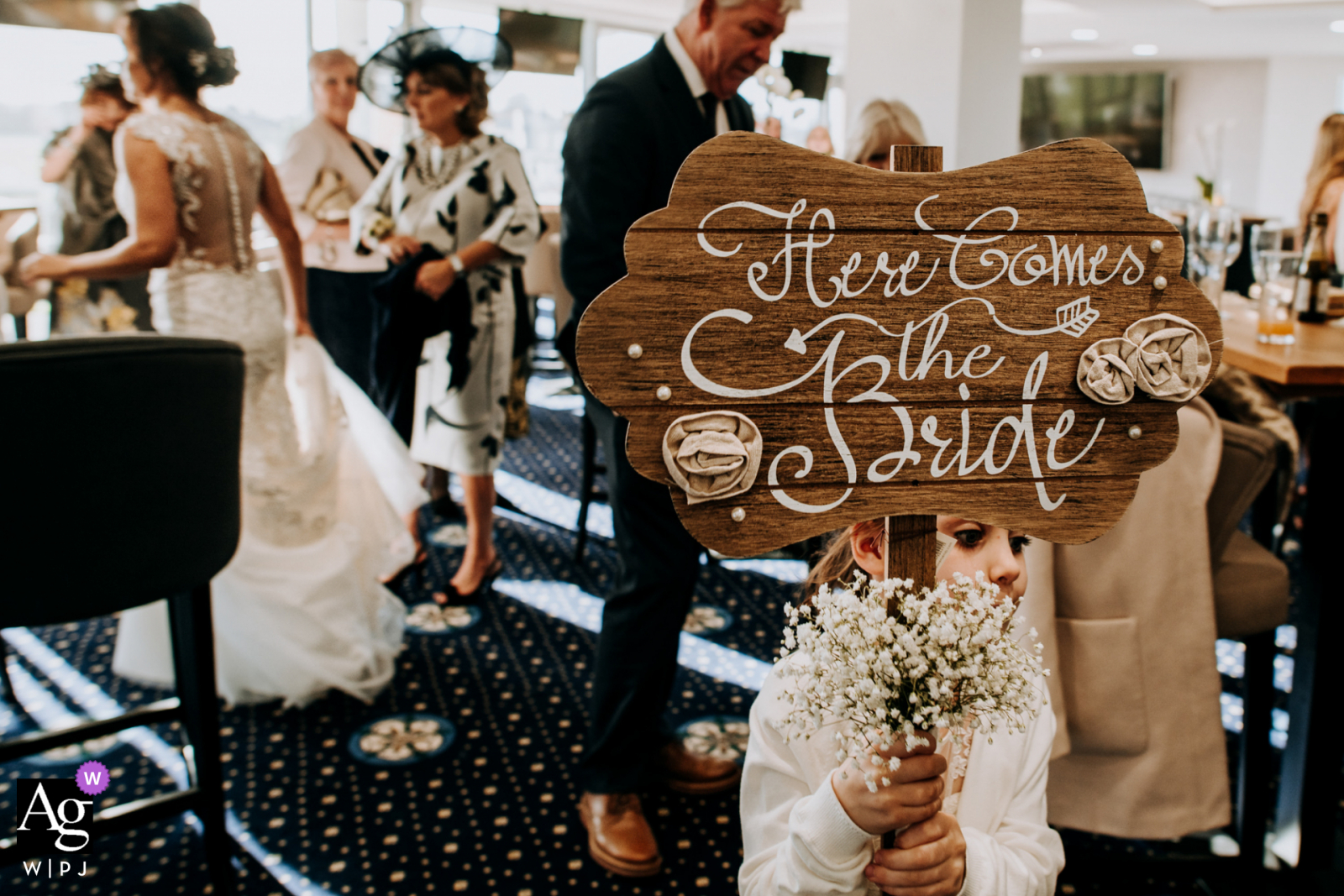 Foto de casamento artístico da Inglaterra da menina das flores segurando sua inscrição mesmo após a cerimônia