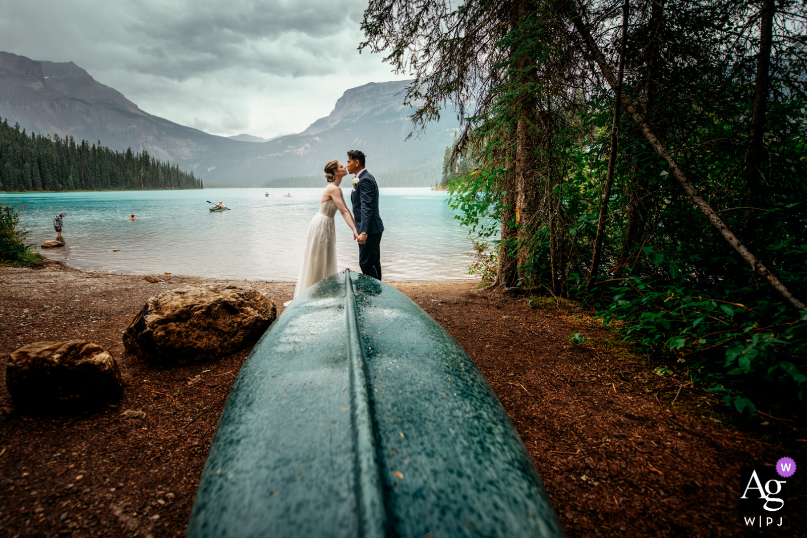 Yoho-Nationalpark-Hochzeitsporträt eines Paares, das sich am Emerald Lake küsst und Händchen hält