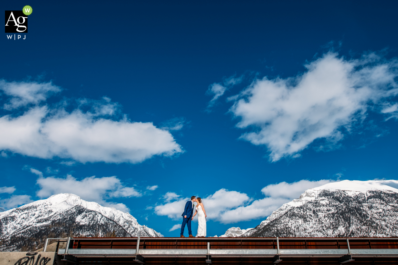 AB pareja posando para una foto de boda en Silvertip Golf Resort, Canmore, AB, Canadá, entre las montañas