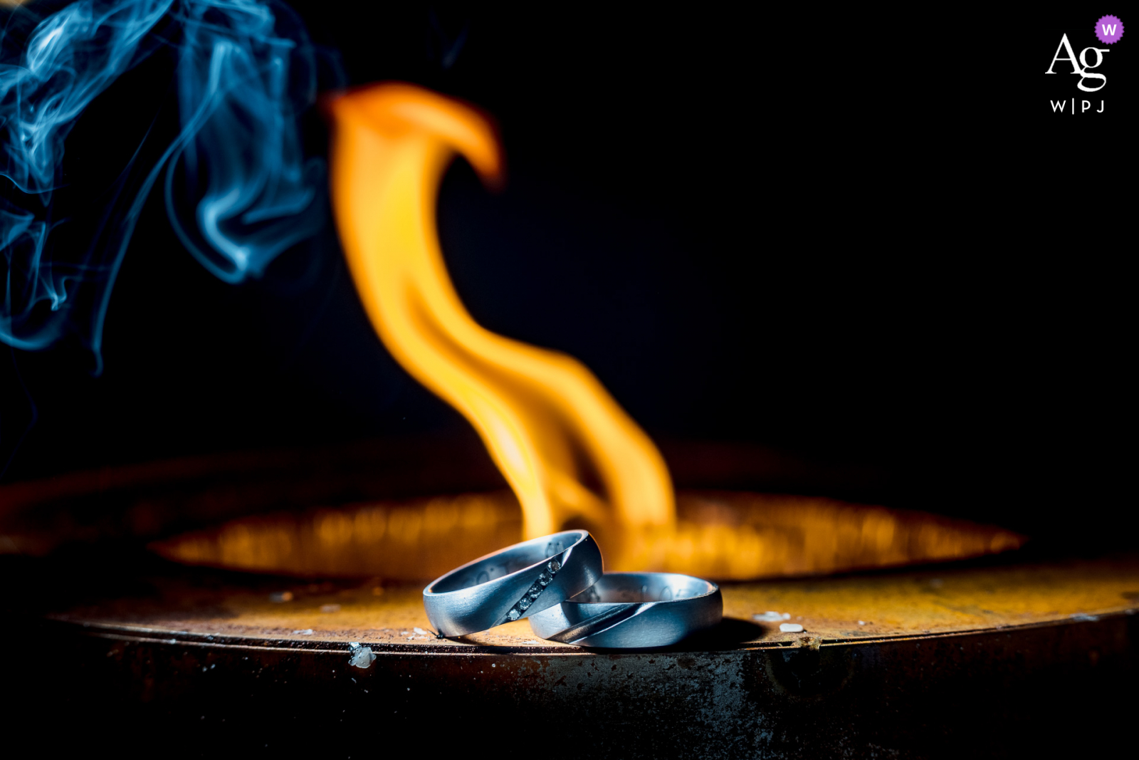 Foto de detalhes de casamento de belas artes de Heuchelberg dos anéis com chamas de fogo e fumaça