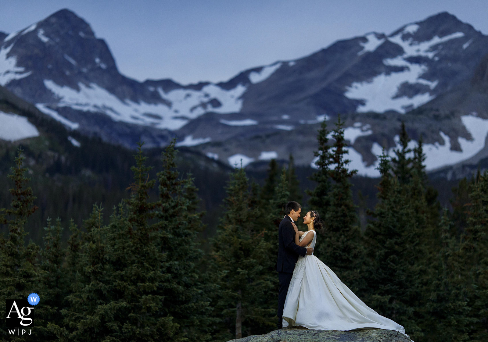 Brainard Lake, Ward, CO, retrato de casamento de casal criativo da noiva e do noivo posando juntos em uma rocha no crepúsculo após sua fuga