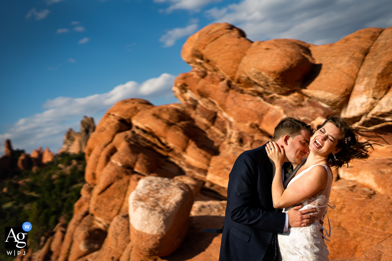 Garden of the Gods Park - كولورادو سبرينغز ، كولورادو زوجان يتعانقان أثناء التقاط صور في يوم زفافهما.