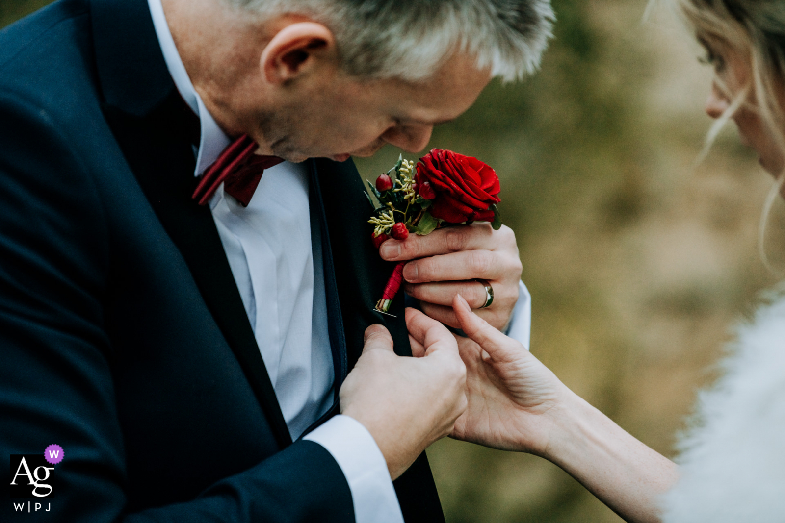 Rudding Park, North Yorkshire, UK wedding reportage image of the Bride assisting groom as he tries to re-attach his buttonhole