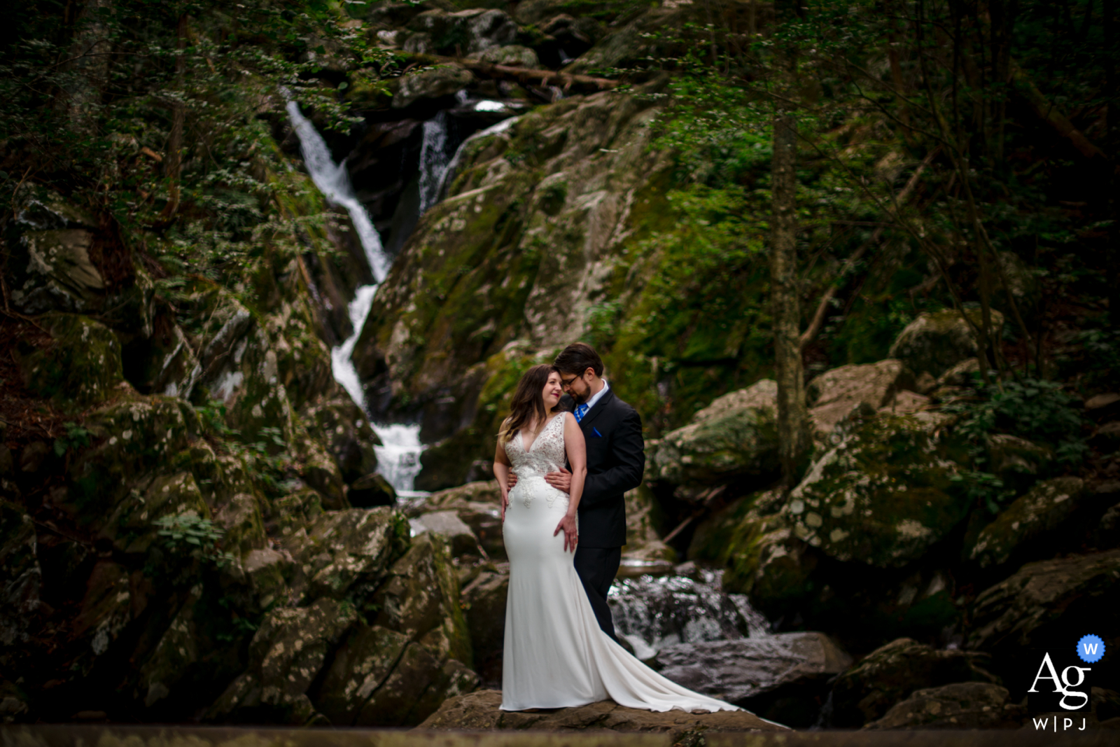 Künstlerisches VA-Hochzeitsfoto aus Shenendoah, Virginia, entstanden, als sich das Paar vor einem Wasserfall umarmt