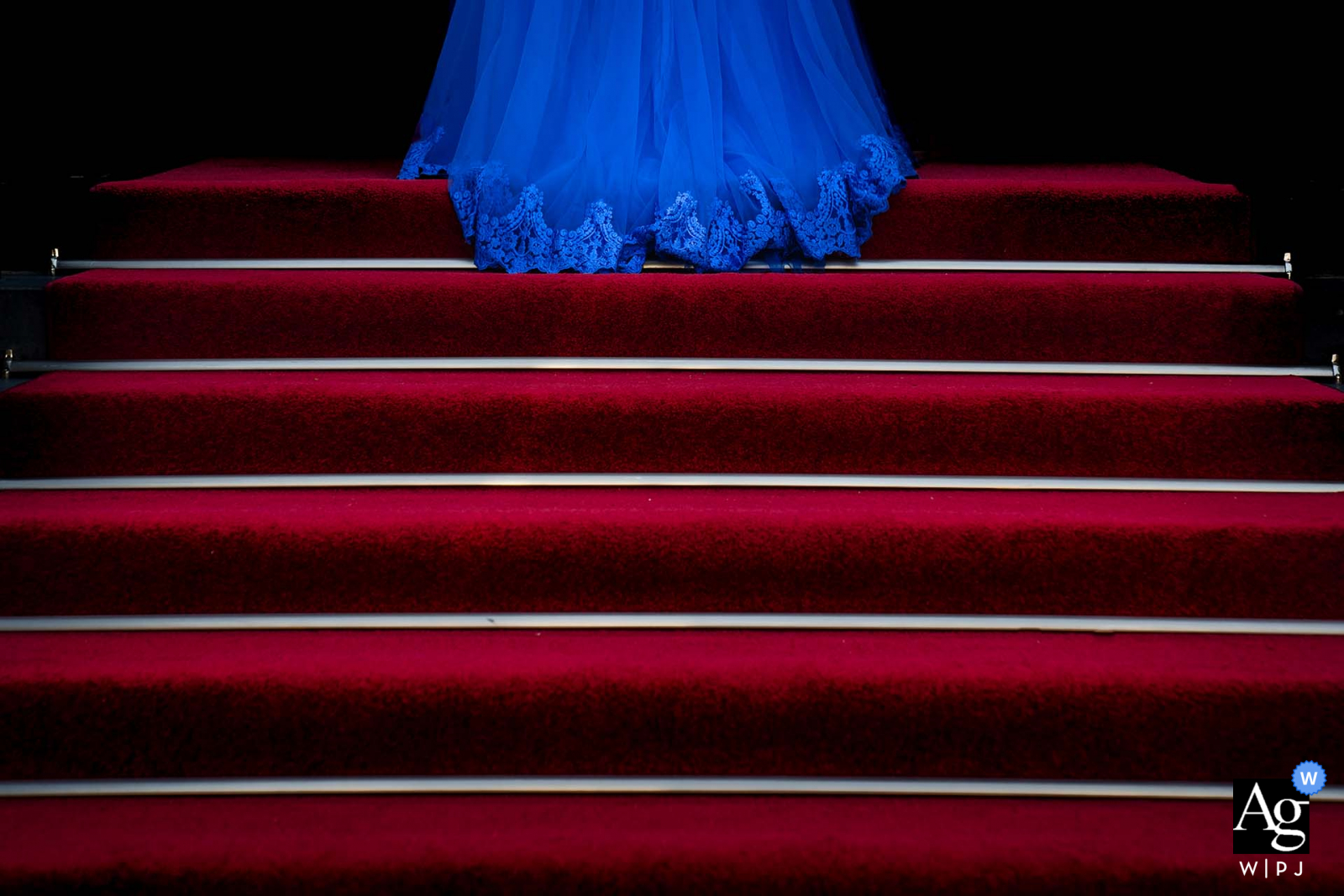 View this dramatic Alblasserdam City Hall wedding image showing The bride is walking up the stairs towards the wedding venue, which was a featured picture among the best wedding photography in Netherlands from the WPJA