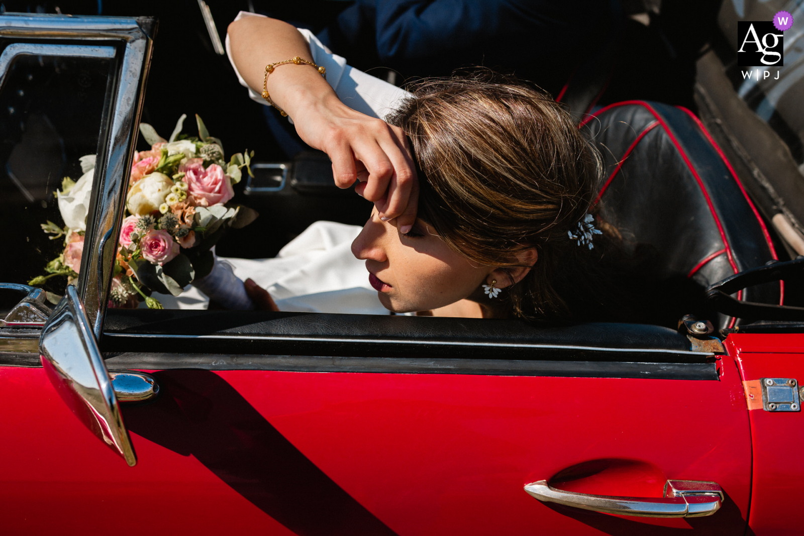 View this creative France wedding detail pic of the bride in a red vintage car which was a featured picture among the best wedding photography from the WPJA