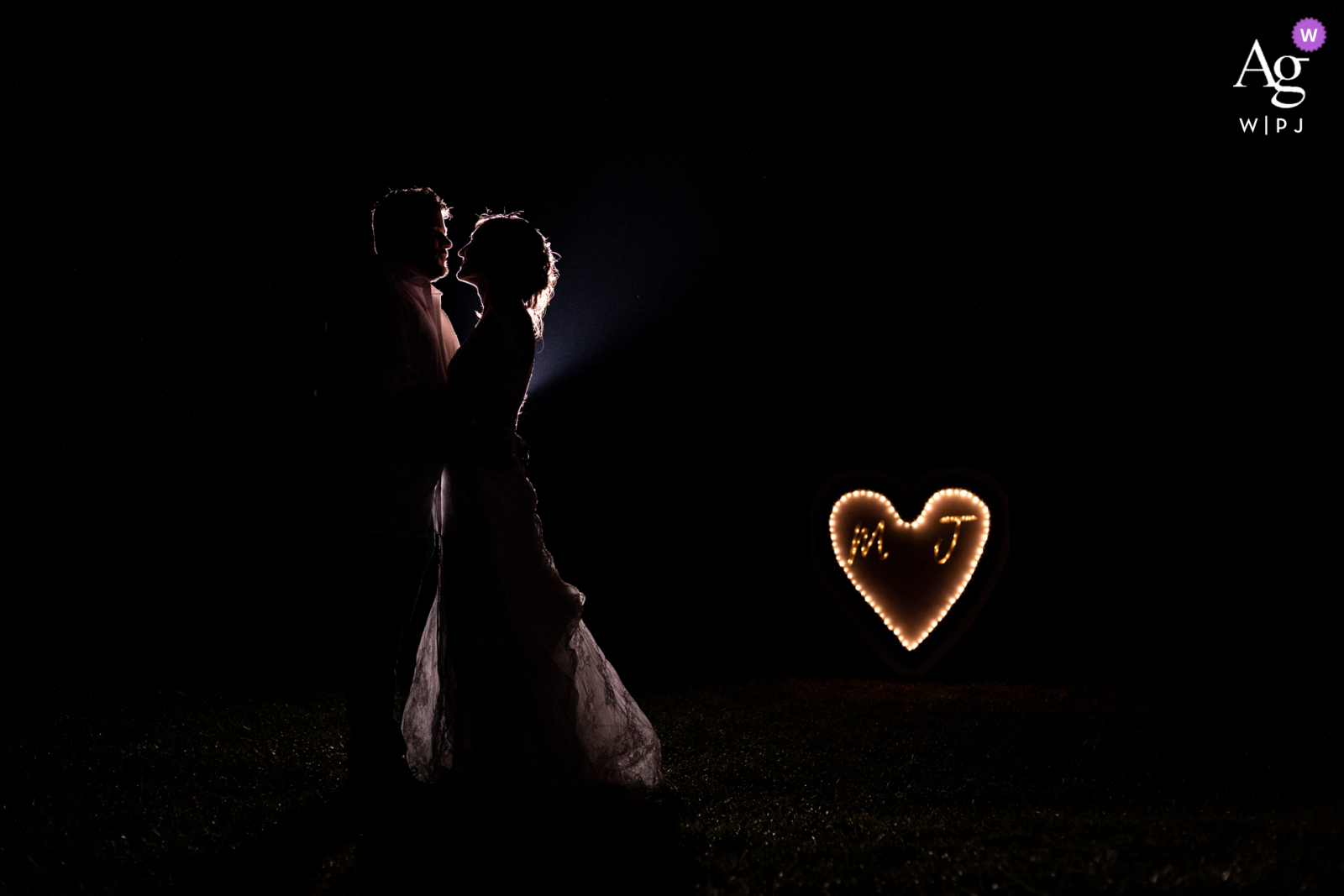World's most innovative and best Denat wedding photography at Les tables de Crespin in South of France during a Night photo session with a kiss with and lighting heart behind