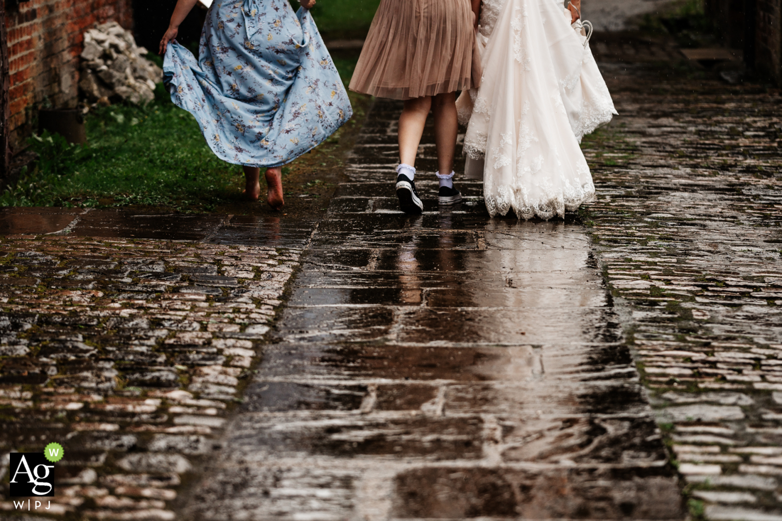 Najwyższej klasy zdjęcie szczegółów ślubu z imprezy weselnej w West Yorkshire w miejscu ślubu Thwaite Mills, pokazujące buty i stopy panny młodej z Wielkiej Brytanii i jej przyjaciół, gdy chodzą w deszczu