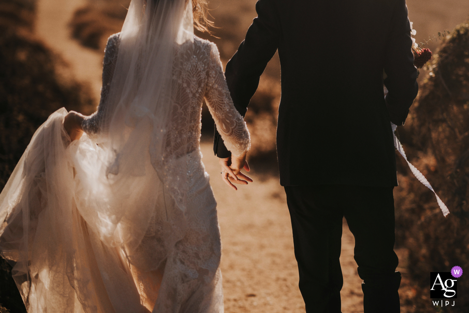 Estilo artístico de fotografia de casamento de San Jose em uma imagem da noiva e do noivo de mãos dadas e andando