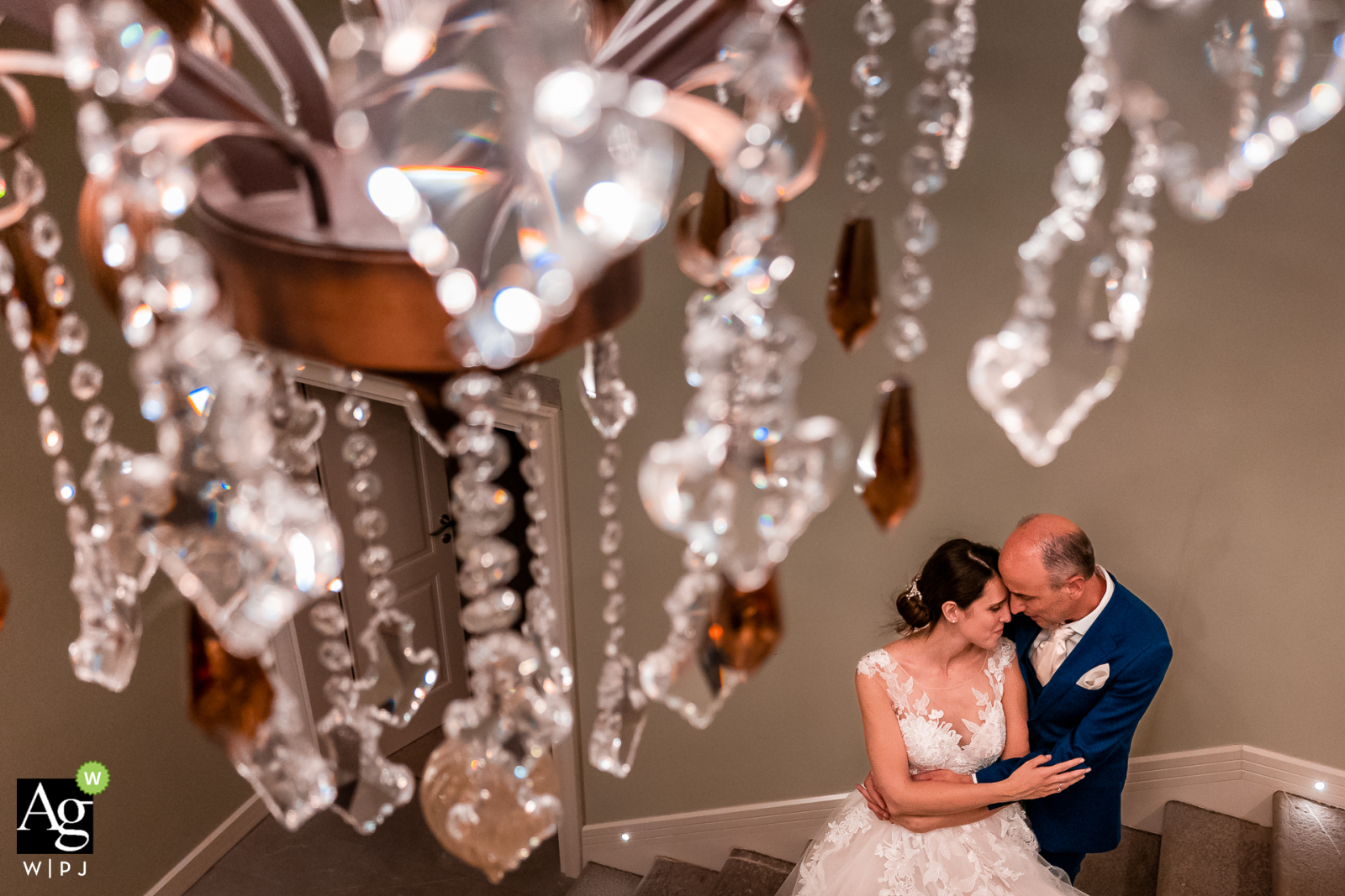 A breathtaking view of the bride and groom under a grand chandelier in the idyllic Villa Al Trovatore in Cervignano, Udine, Italy