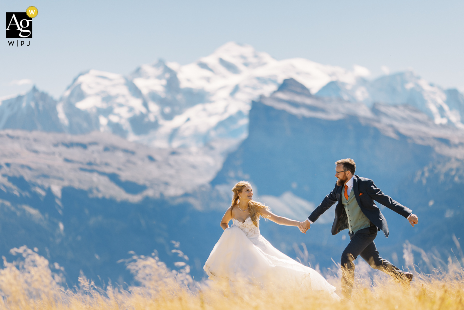 A wedding couple is running in front of the Mont Blanc mountain
