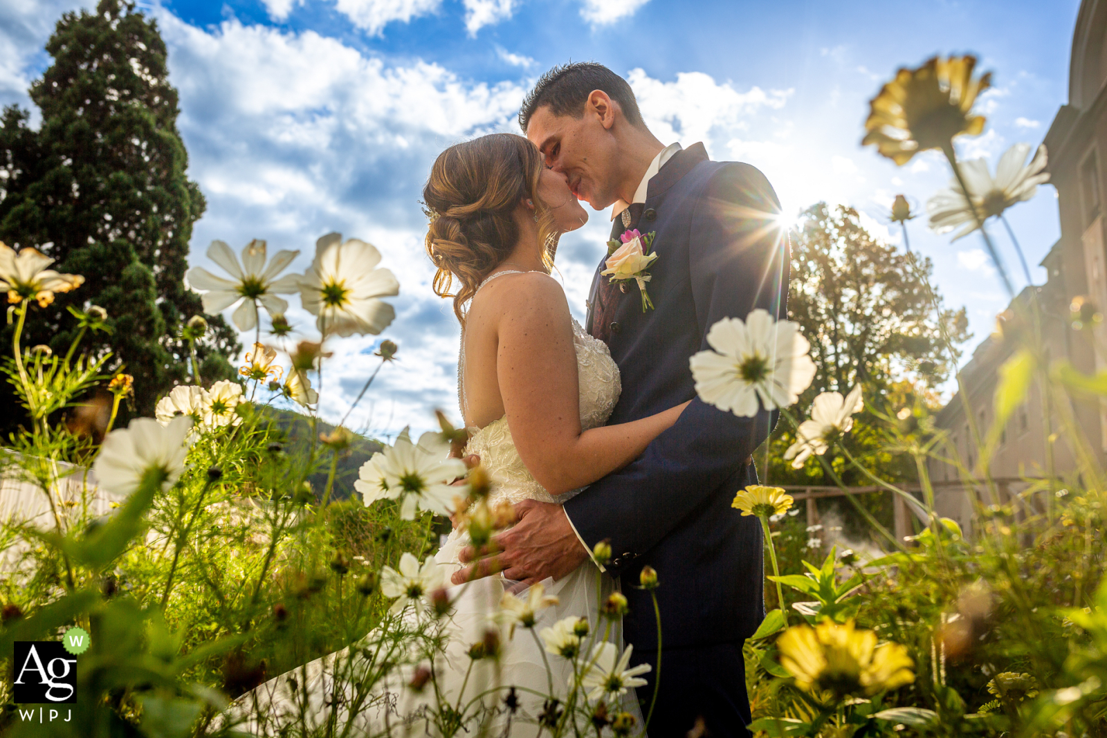 The kissing couple in the Parc de Wesserling in Alsace, surrounded by a thousand and one flowers and unmeasurable love, basked in the sunshine of the flower fields for their wedding picture