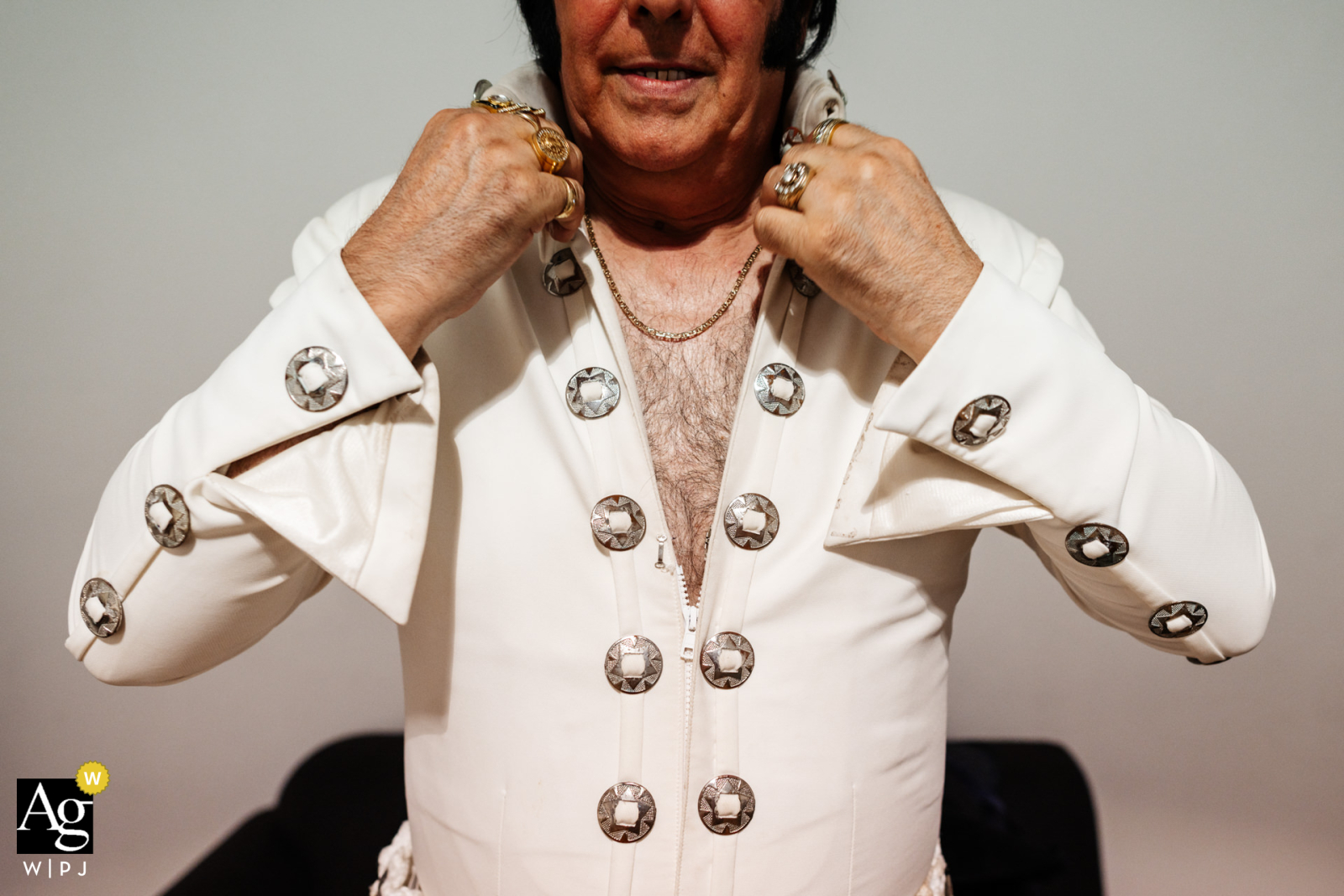 En los muelles de Hoxton de Londres, un imitador de Elvis, vestido con un llamativo traje vintage, se ajusta meticulosamente su gran cuello blanco antes de subir al escenario en una boda.