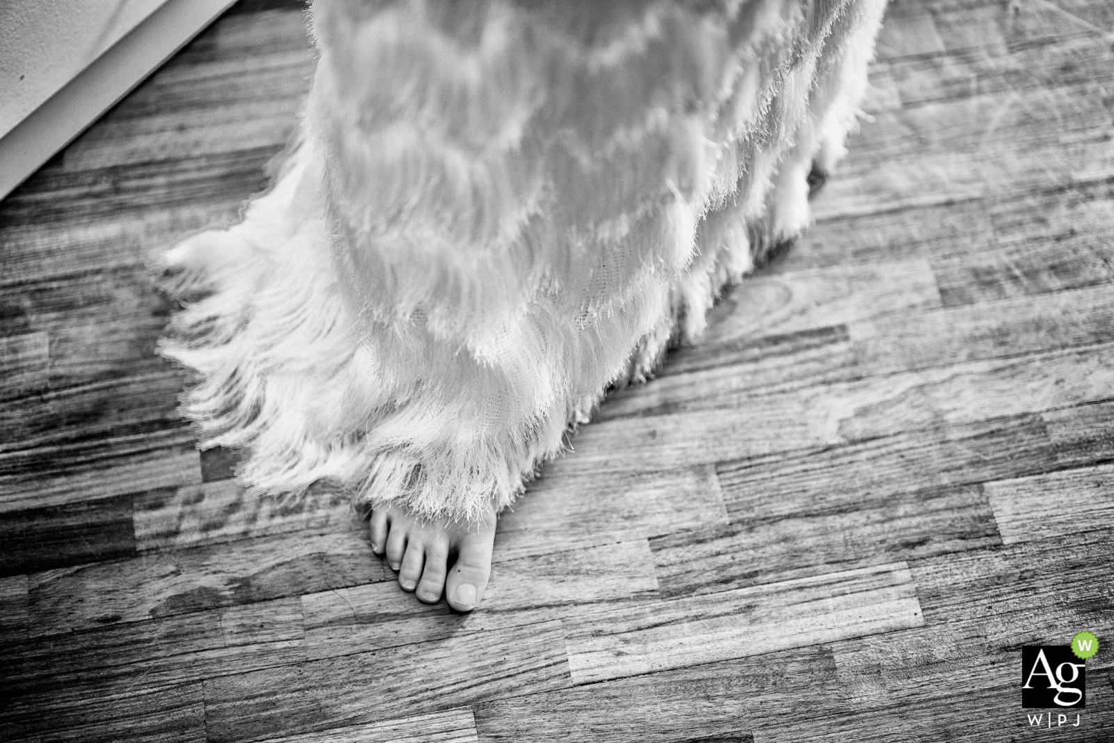 Bride's Foot, Dress Detail Adds Whimsy to Iseo Wedding At I Due Roccoli in Iseo, a black-and-white detail shot reveals one of the bride's feet peeking out from beneath her wedding dress. The image captures a delicate and intimate scene, adding a touch of whimsy to her elegant attire.