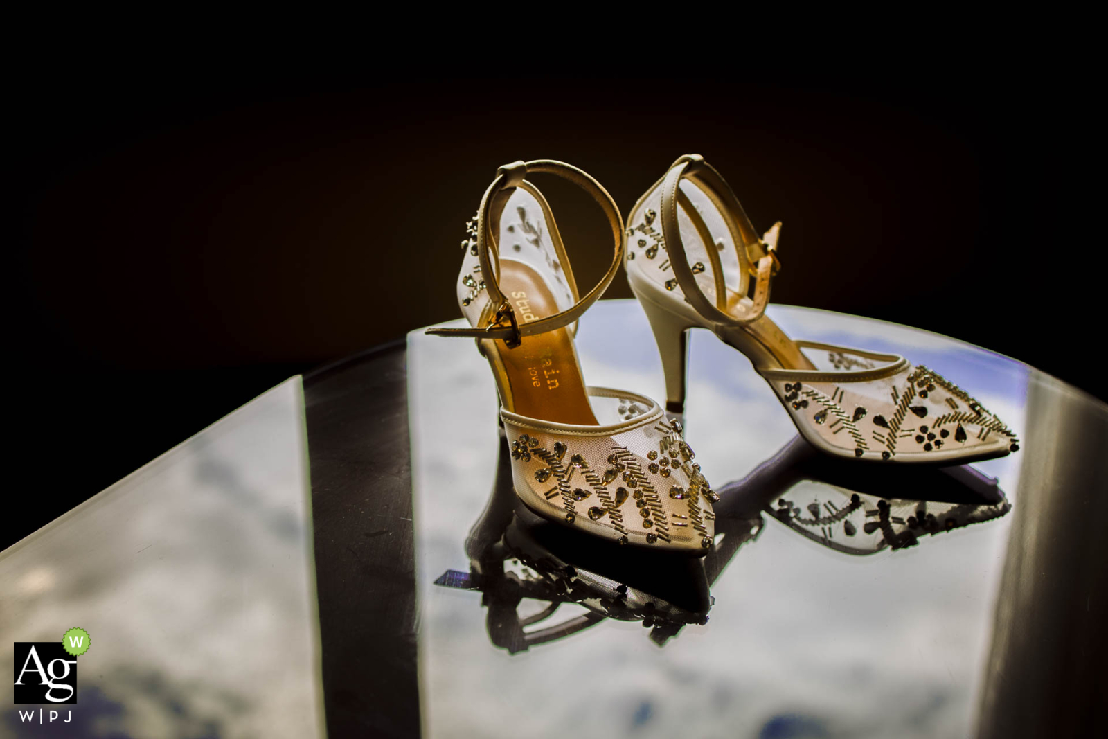 At Mersin Hilton Hotel, the bride's shoes are elegantly displayed, their image reflected on the glass surface. This detail shot captures the sparkle and style of the wedding shoes.