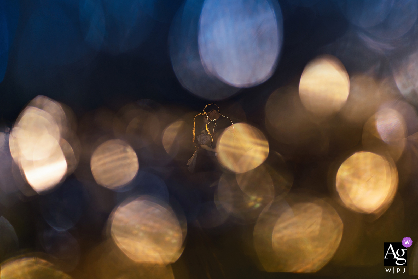 On Fujian Hotel's lawn, the bride and groom pose with beautiful bokeh lights creating a dreamy, romantic backdrop