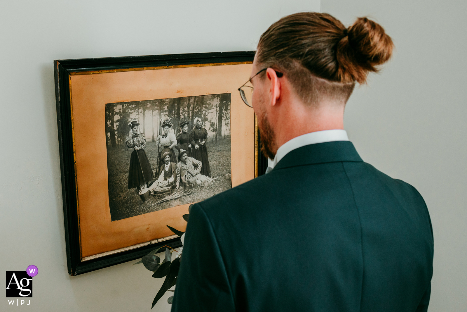 At Domaine de la Clausade, Mauguio, the groom turns for a first look, poignantly framed by a group photo of ancestral elders.