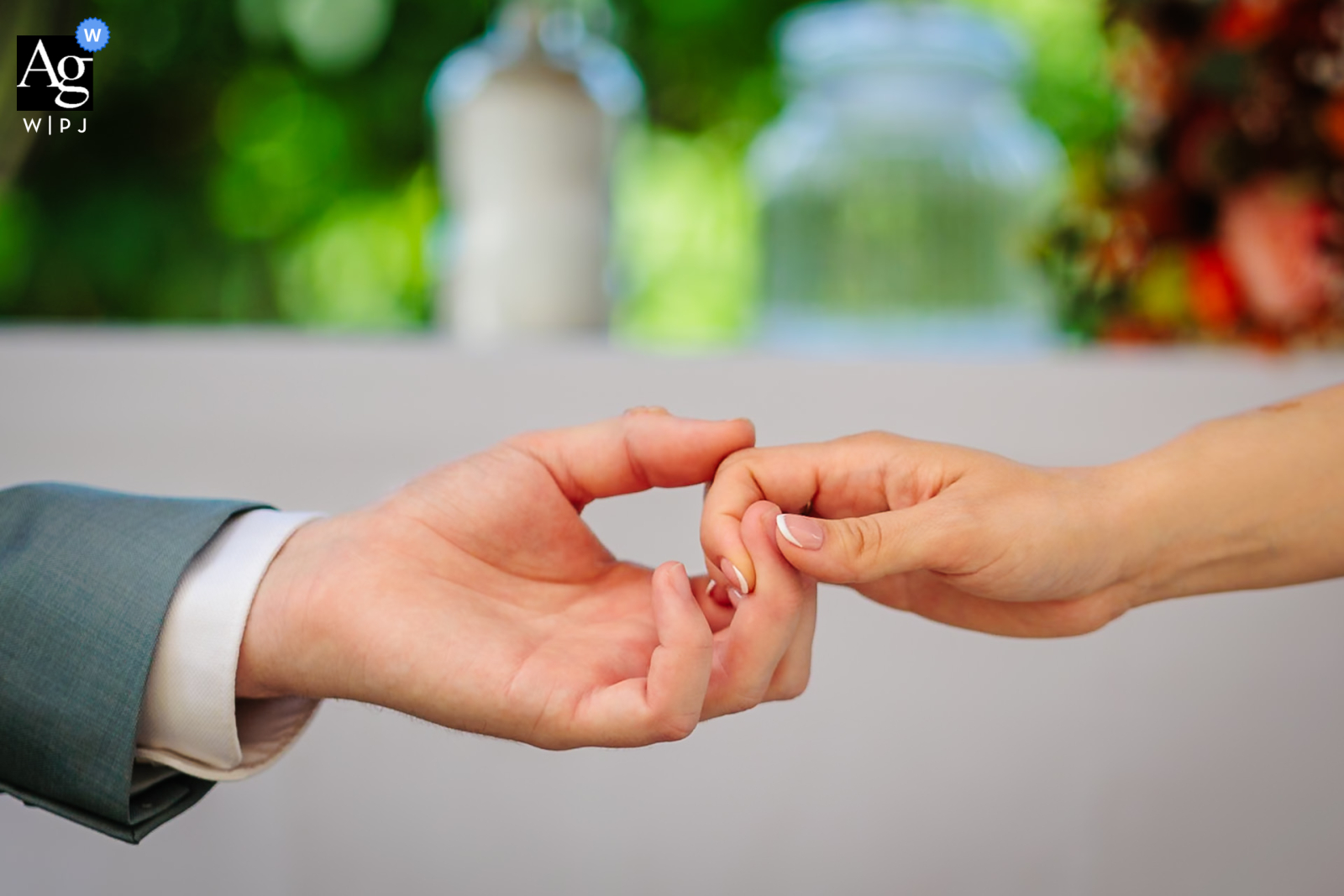 At Chloé du Lac, Montferrat, France, the bride and groom tenderly hold hands during the ceremony, capturing the intimacy and commitment of their vows amid the picturesque setting.