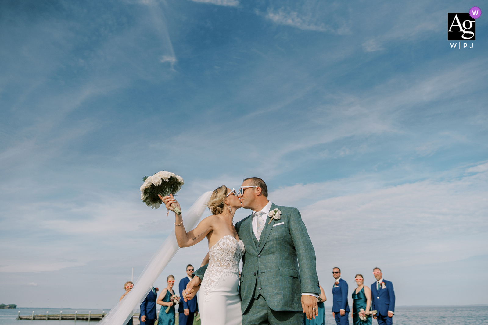In Fond du Lac, Wisconsin, a bride and groom embraced for a kiss with their wedding party in the background.