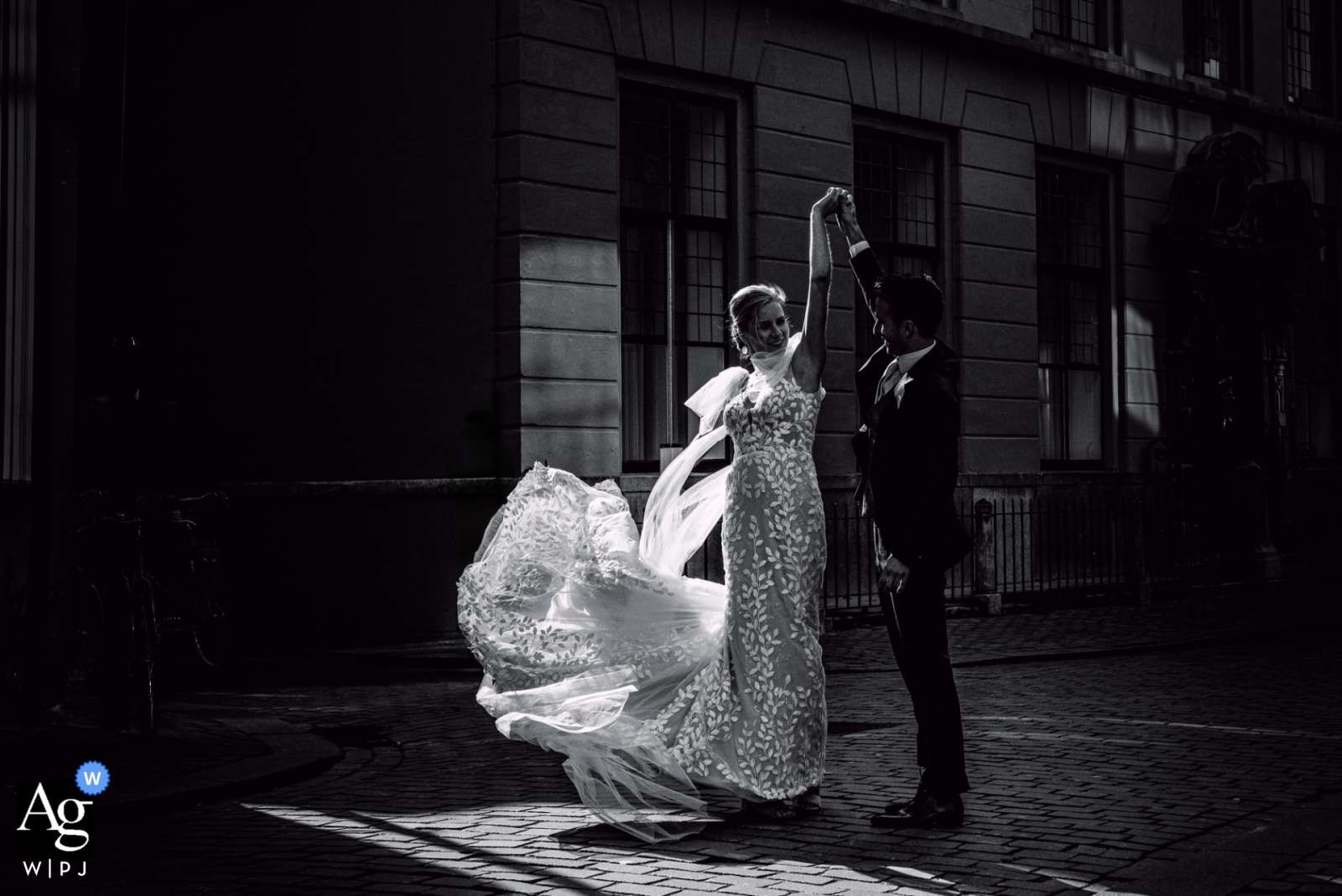 At their ceremony location in Breda, the Netherlands, the couple poses in the afternoon light of the city center, captured in a black-and-white photo that highlights their romance in the streets.