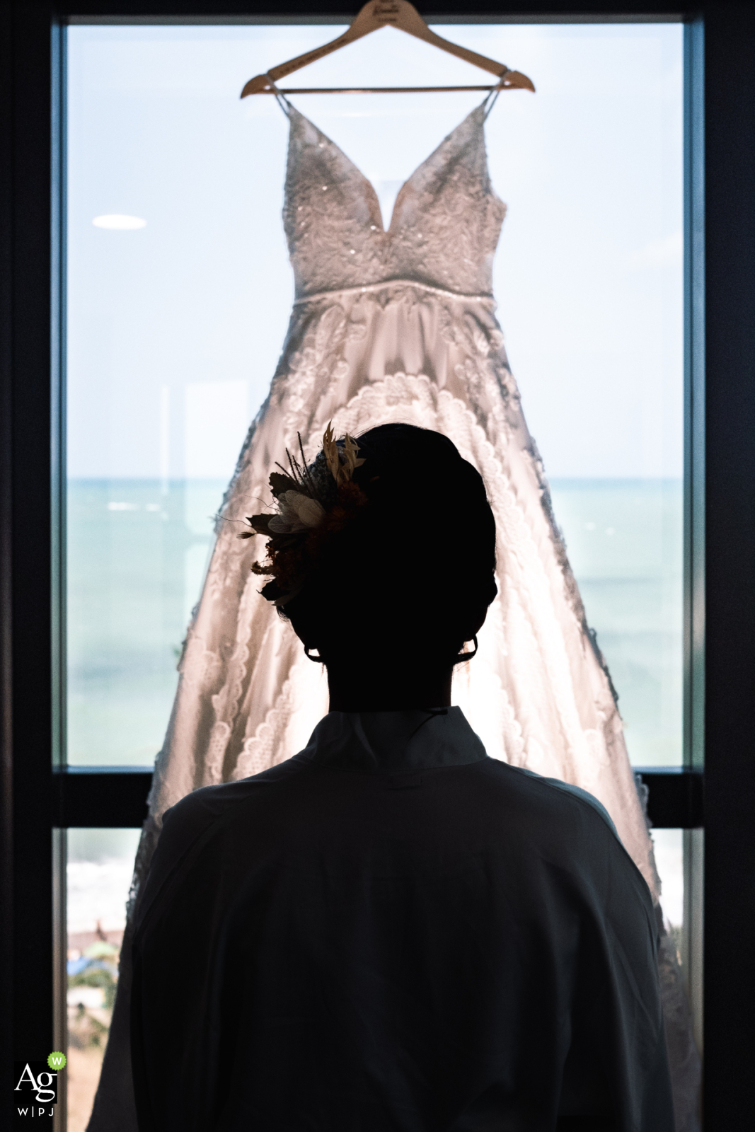 Elegant bride silhouetted at Hotel Ritz, showcasing her gown's detail against a softly lit backdrop.