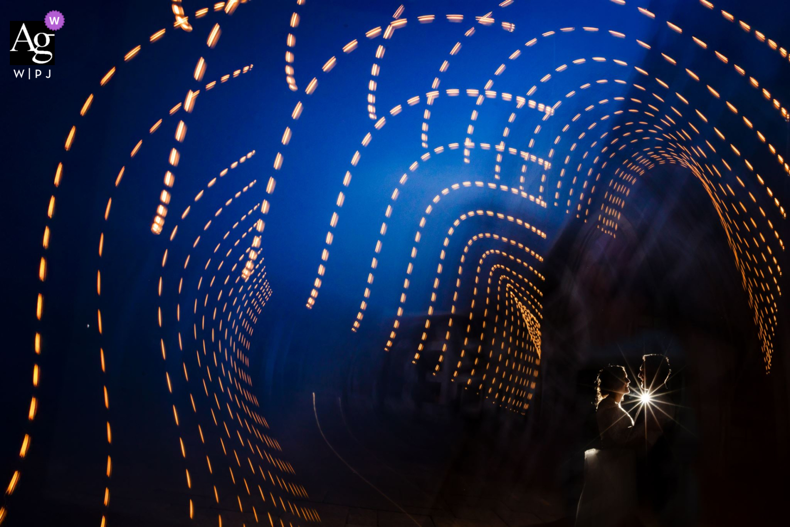At DoubleTree in Colorado Springs, Colorado, a slow shutter captures string light trails as flash backlights the bride and groom, creating a dynamic, illuminated wedding portrait.